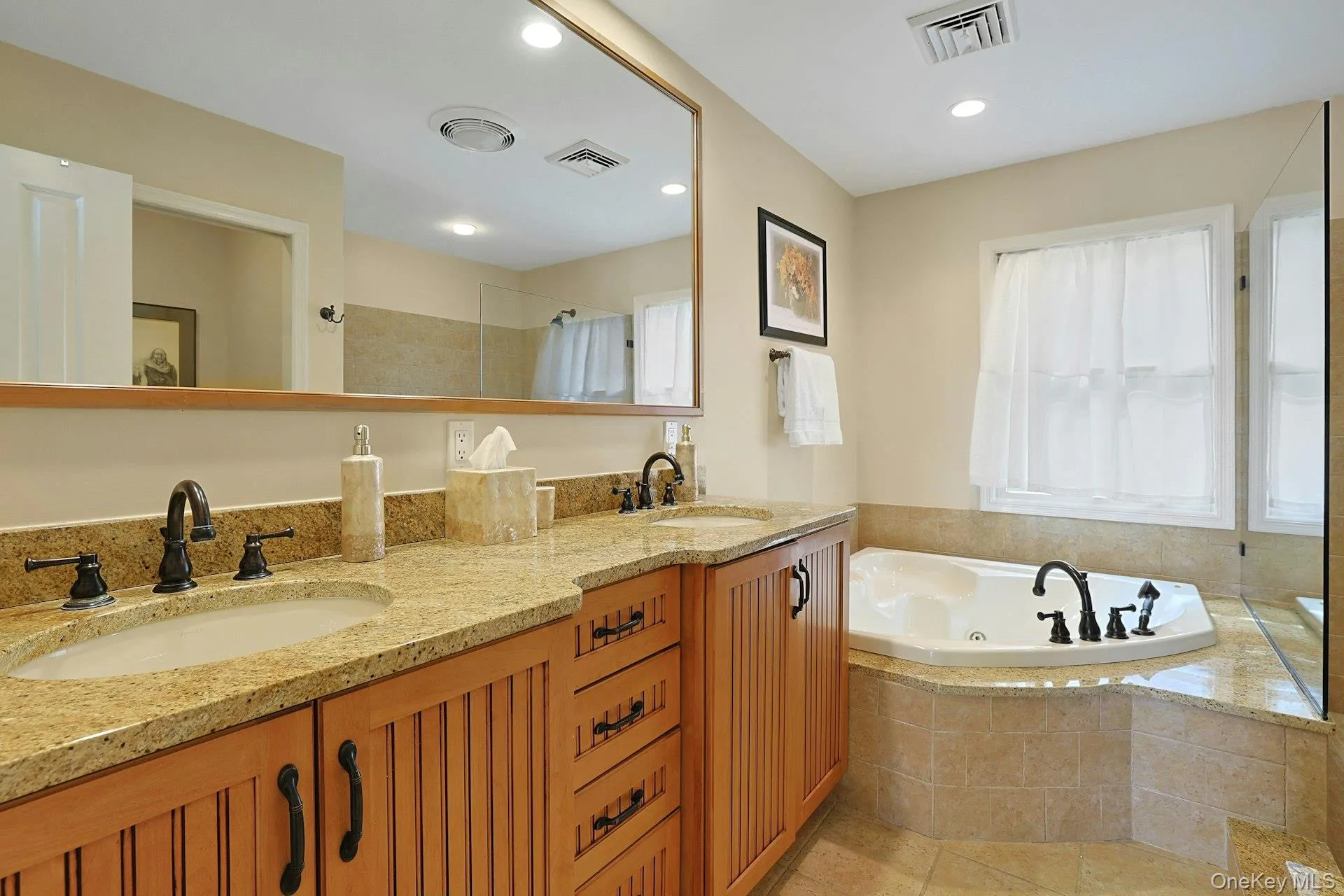 Unwind in the gorgeous en suite primary bathroom, featuring a double vanity and a relaxing Jacuzzi tub—the perfect place to end the day. Unwind in the gorgeous en suite primary bathroom, featuring a double vanity and a relaxing Jacuzzi tub—the perfect place to end the day.