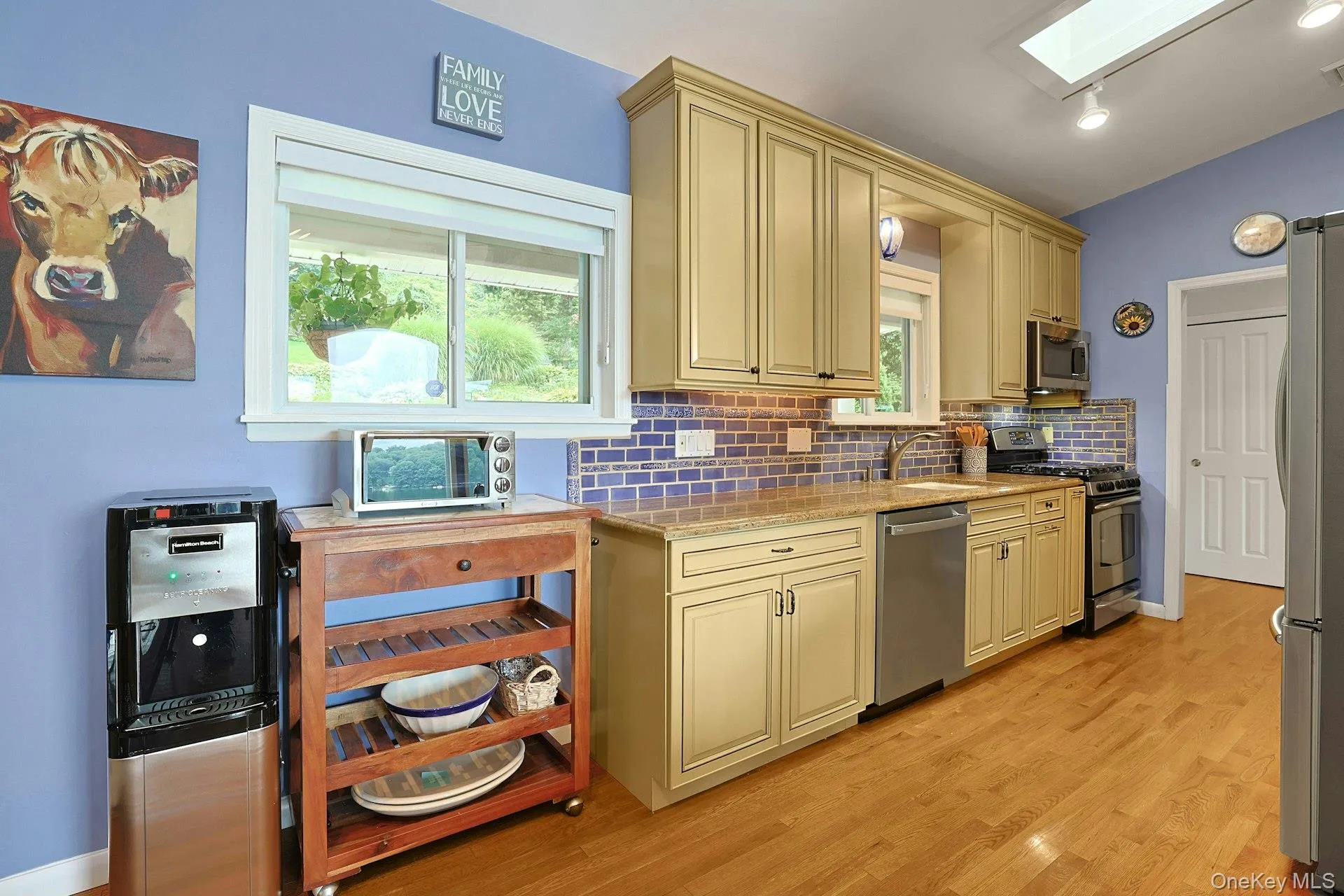 The kitchen windows frame peaceful views of the frontyard and garden, bringing natural light and the surrounding greenery in. At this end lies a mudroom/additional laundry area and pantry closet. The kitchen windows frame peaceful views of the frontyard and garden, bringing natural light and the surrounding greenery in. At this end lies a mudroom/additional laundry area and pantry closet.