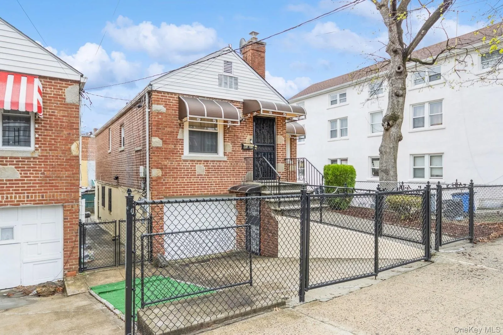 View of front with brick , fence, and a gate View of front with brick , fence, and a gate