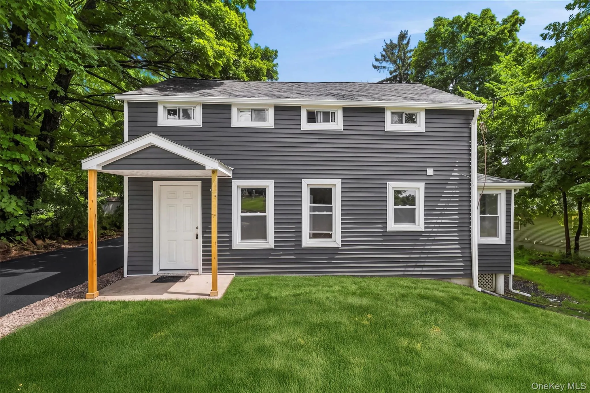 Dark gray siding exterior with white trim windows and a covered front entry Dark gray siding exterior with white trim windows and a covered front entry