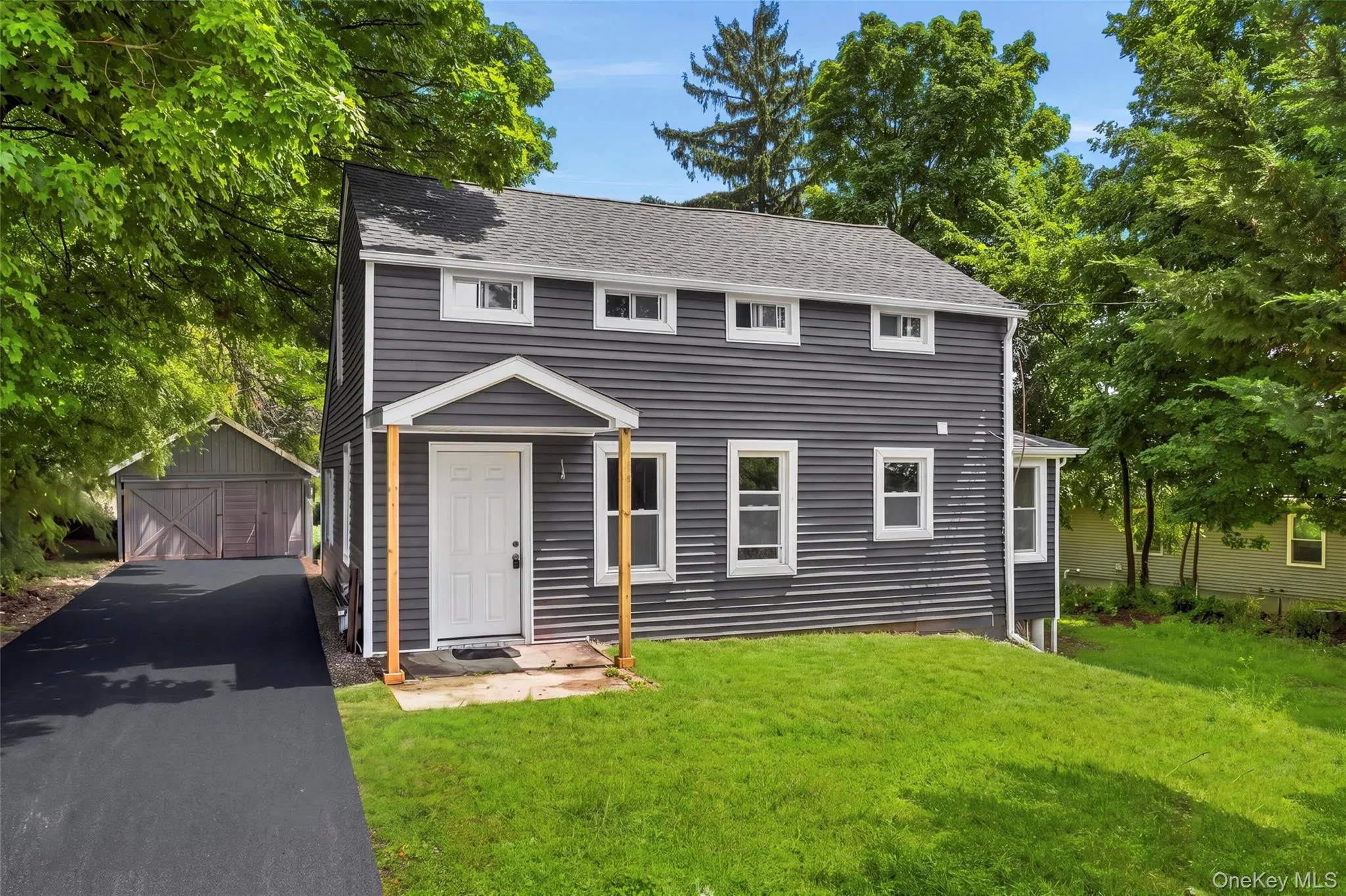 Charcoal gray siding exterior with white trim windows and a covered entryway Charcoal gray siding exterior with white trim windows and a covered entryway
