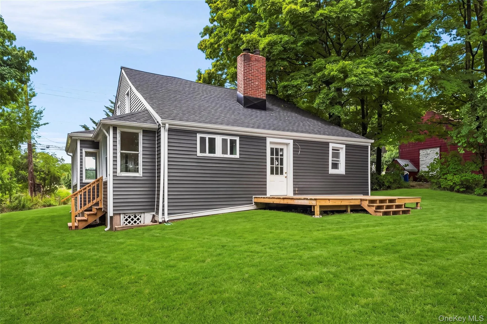 Exterior featuring dark gray siding, white trim, and a gray shingle roof Exterior featuring dark gray siding, white trim, and a gray shingle roof