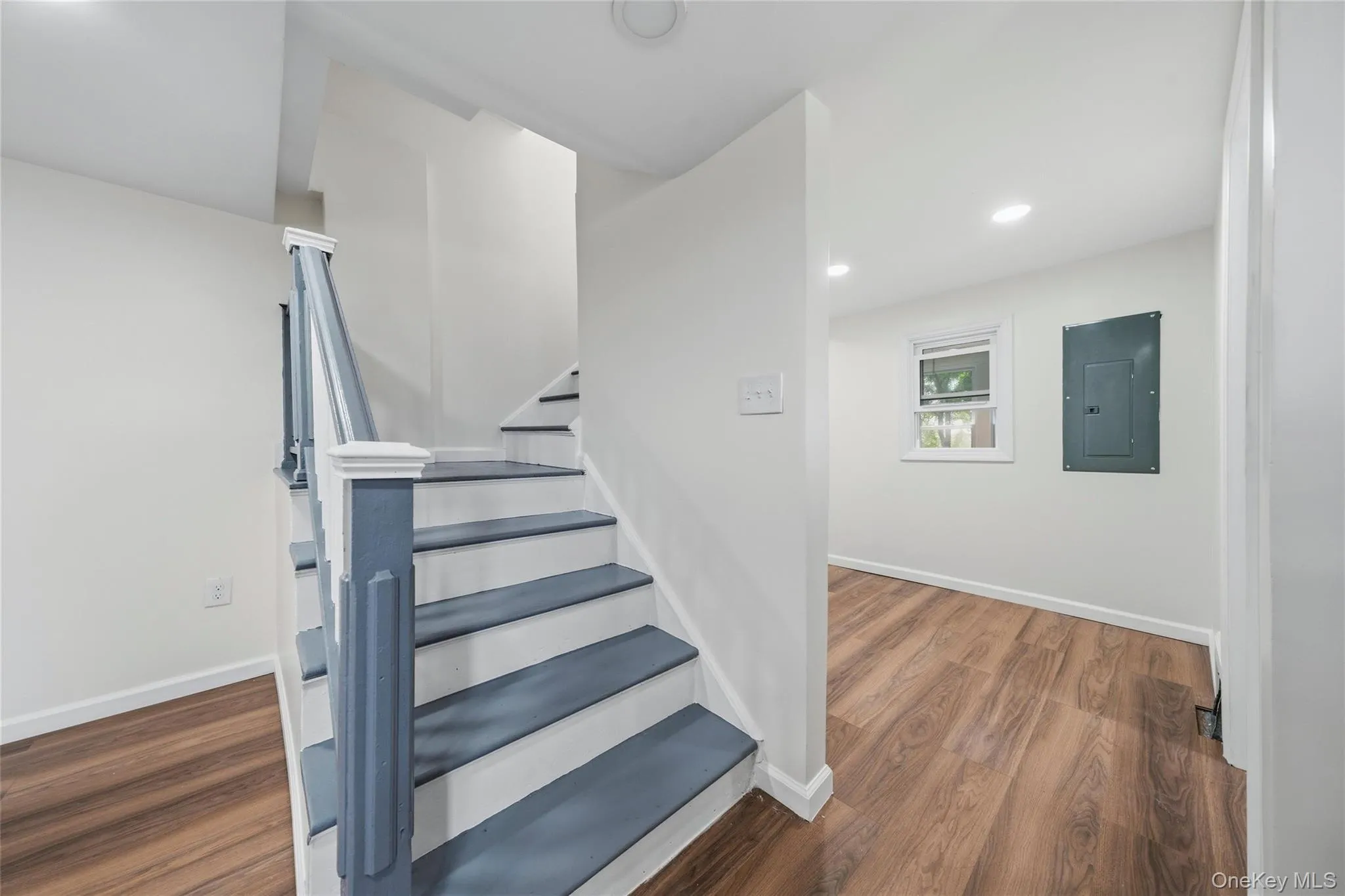 Staircase featuring blue-painted risers and white treads with wood-finish flooring Staircase featuring blue-painted risers and white treads with wood-finish flooring