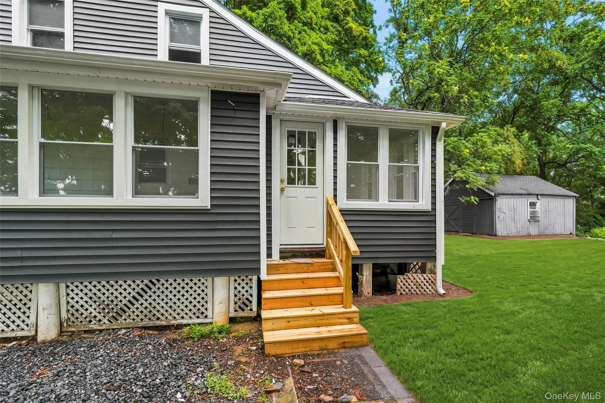 Dark gray horizontal siding exterior with white window trim and a white paneled entry door Dark gray horizontal siding exterior with white window trim and a white paneled entry door