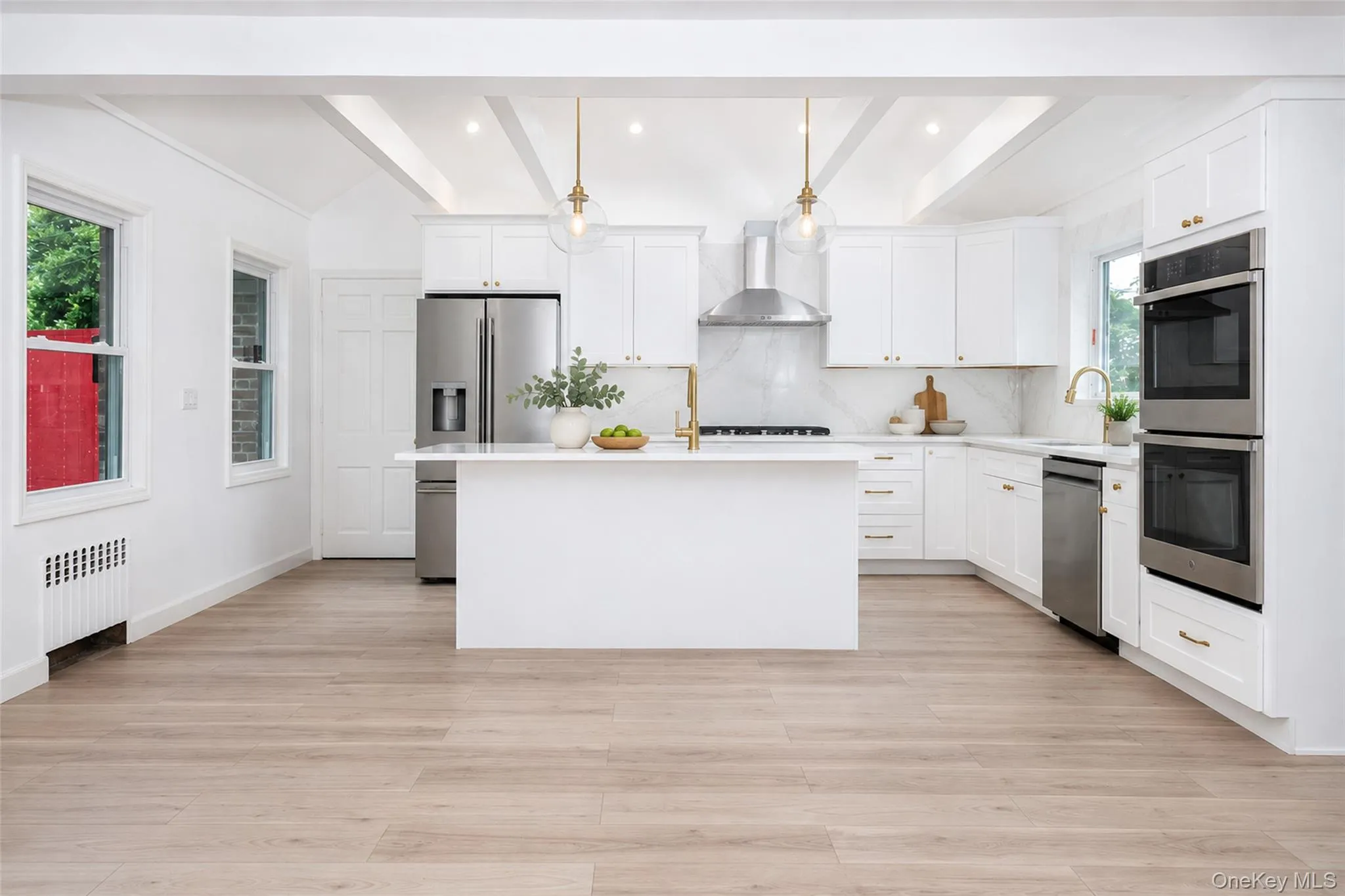 Chef's kitchen featuring two sinks, stainless steel appliances, skylight, and exposed beams. Chef's kitchen featuring two sinks, stainless steel appliances, skylight, and exposed beams.