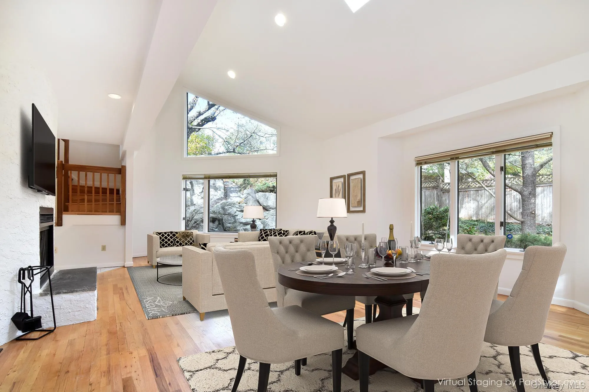 Virtually staged Living/Dining area with high vaulted ceiling, light wood flooring, recessed lighting, and a fireplace Virtually staged Living/Dining area with high vaulted ceiling, light wood flooring, recessed lighting, and a fireplace