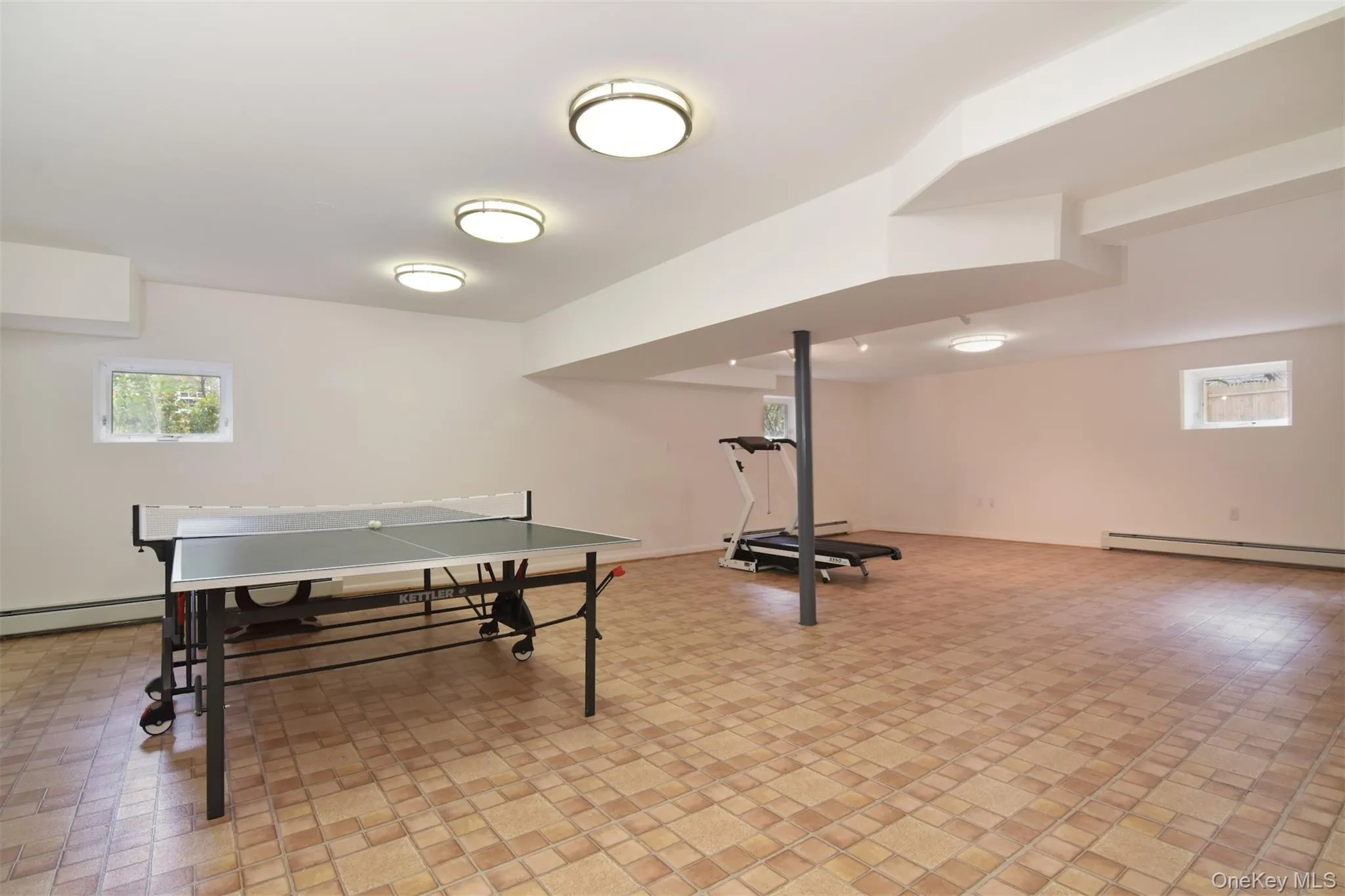 Game room featuring plenty of natural light and baseboard heating Game room featuring plenty of natural light and baseboard heating