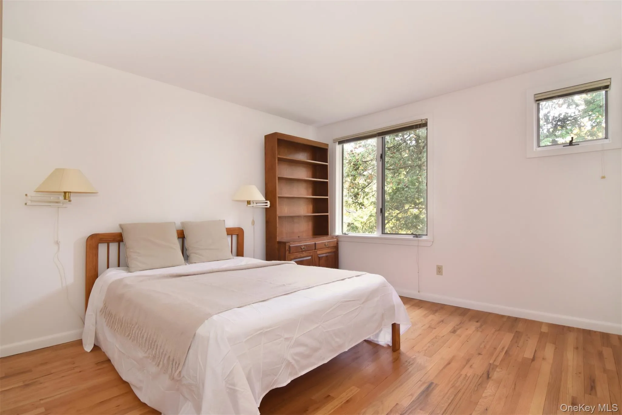 Large second Bedroom with light wood finished floors and 2 closets Large second Bedroom with light wood finished floors and 2 closets