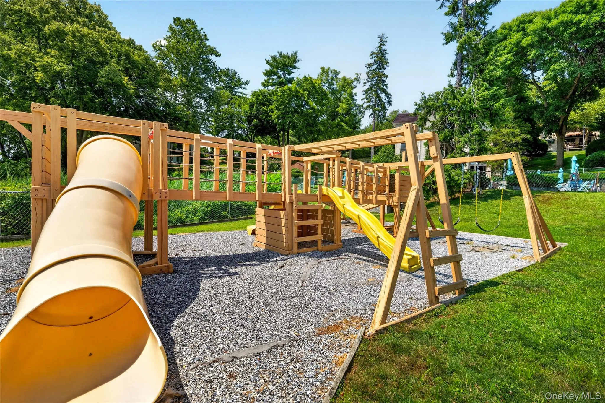 Backyard playground featuring a tube slide, open slide, monkey bars, and swings Backyard playground featuring a tube slide, open slide, monkey bars, and swings