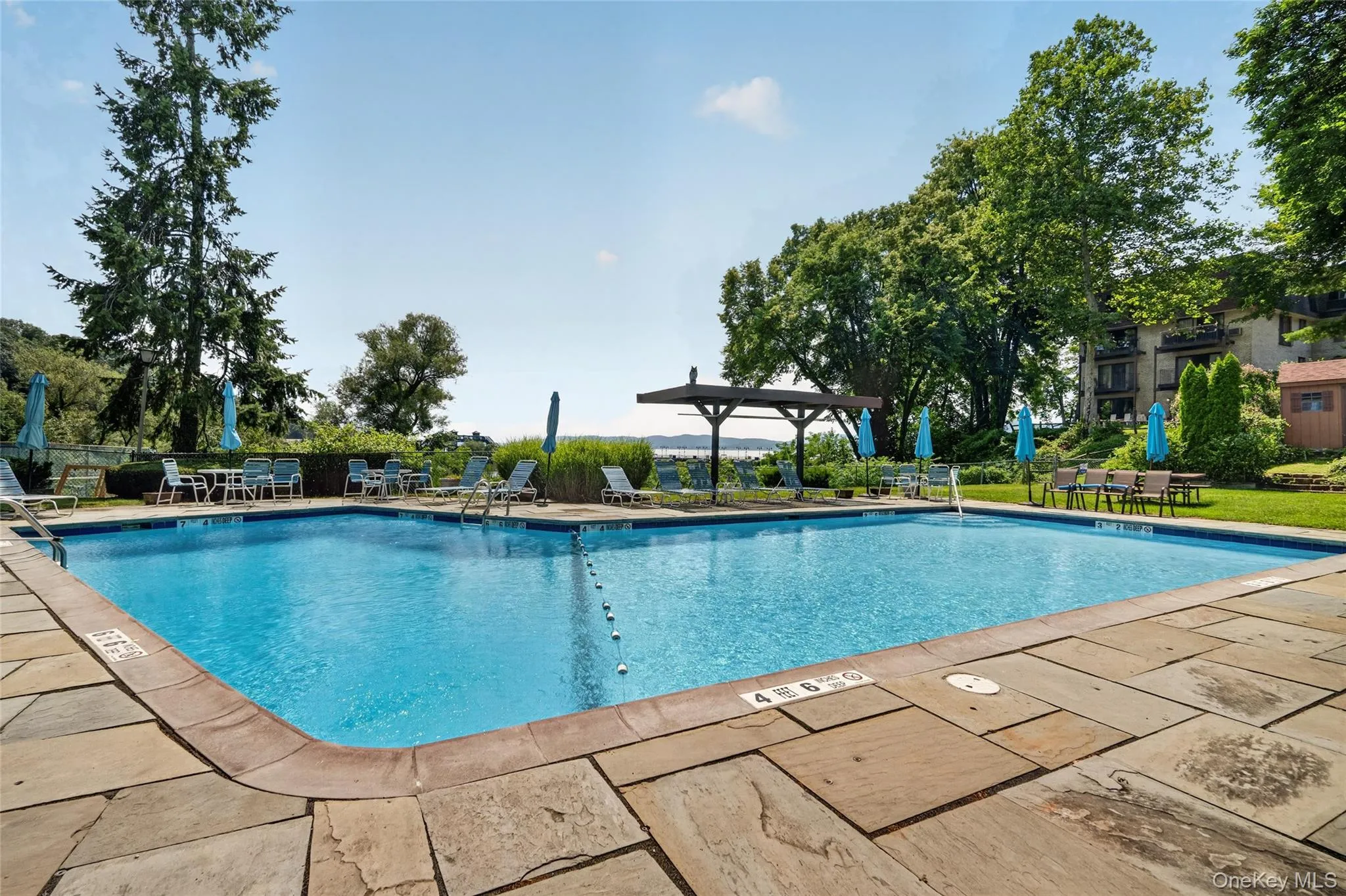 Outdoor swimming pool surrounded by flagstone paving Outdoor swimming pool surrounded by flagstone paving