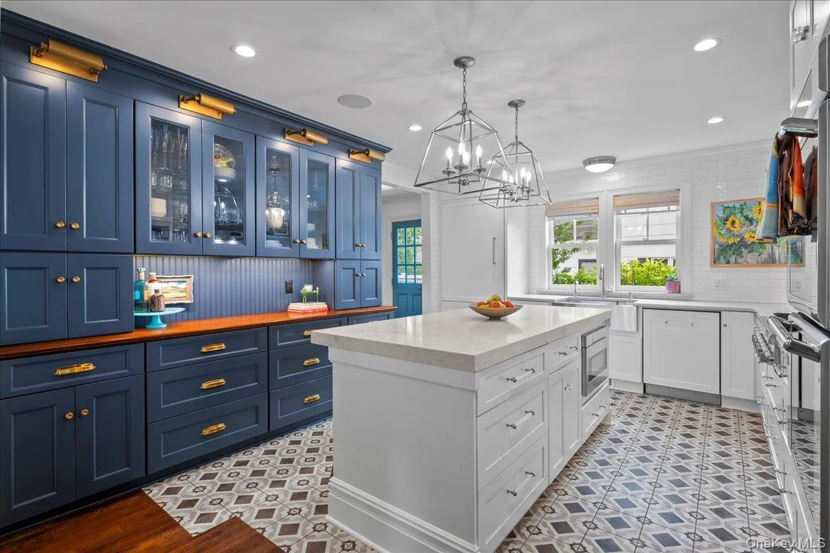 The custom kitchen features an island with quartz countertop, built-in microwave, and ample cabinetry and storage, in addition to beautiful custom cabinetry along the back wall of the kitchen perfect for pantry storage. The custom kitchen features an island with quartz countertop, built-in microwave, and ample cabinetry and storage, in addition to beautiful custom cabinetry along the back wall of the kitchen perfect for pantry storage.