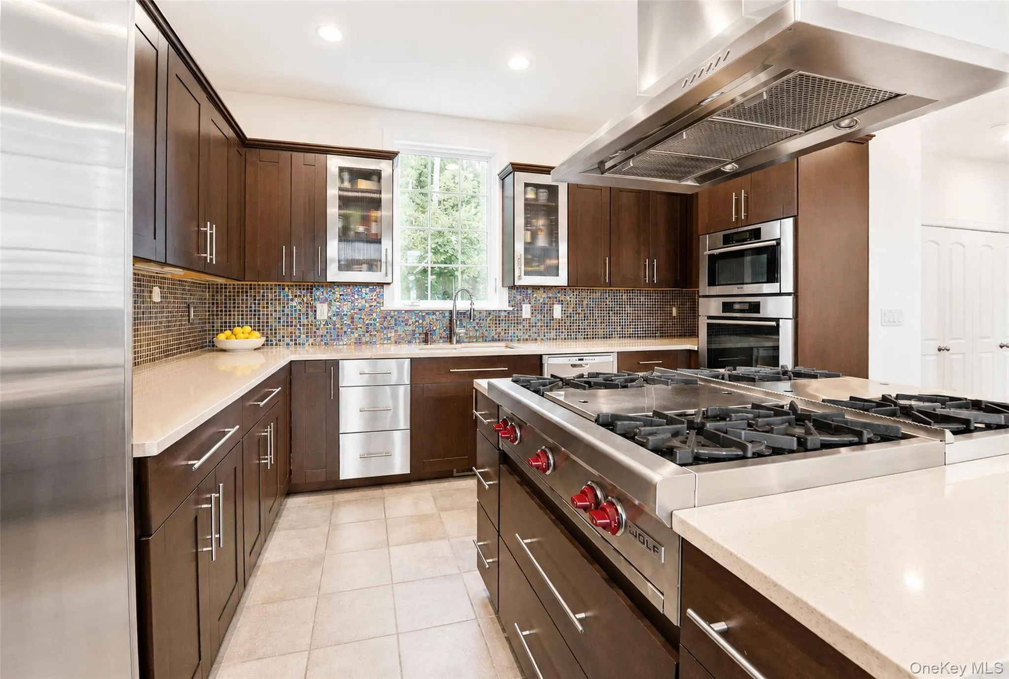 Designed for both culinary excellence and entertaining, this exceptional chef’s kitchen showcases premium stainless steel appliances, double Wolf gas ranges, double ovens, and generous countertop space for seamless preparation and gathering. Designed for both culinary excellence and entertaining, this exceptional chef’s kitchen showcases premium stainless steel appliances, double Wolf gas ranges, double ovens, and generous countertop space for seamless preparation and gathering.