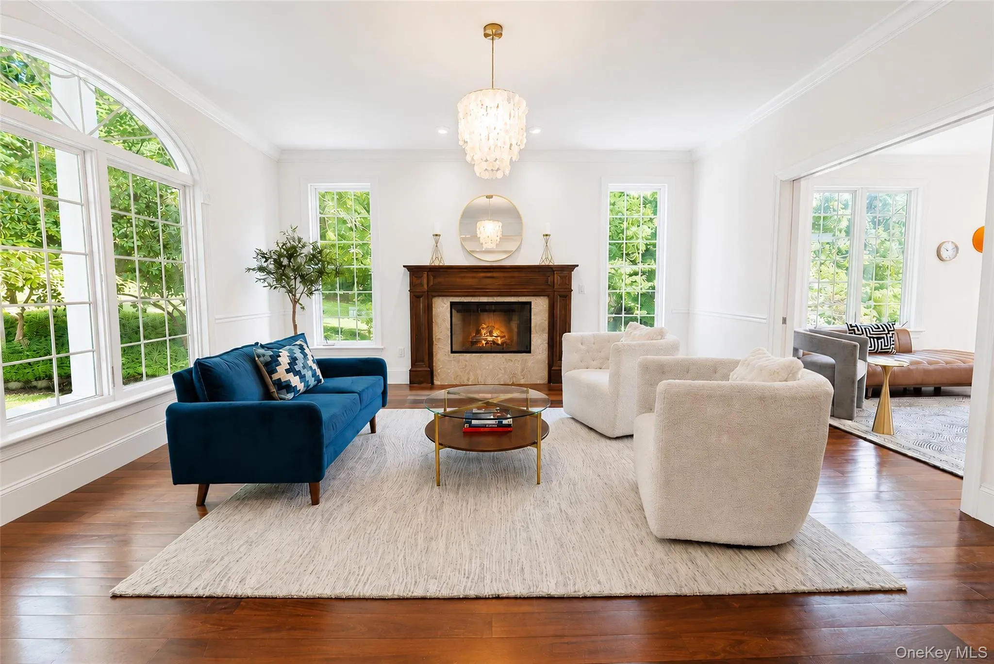 Elegant and inviting, this exceptional den showcases a gas fireplace, statement chandelier, and a wall of windows offering abundant natural light and beautiful views. Elegant and inviting, this exceptional den showcases a gas fireplace, statement chandelier, and a wall of windows offering abundant natural light and beautiful views.