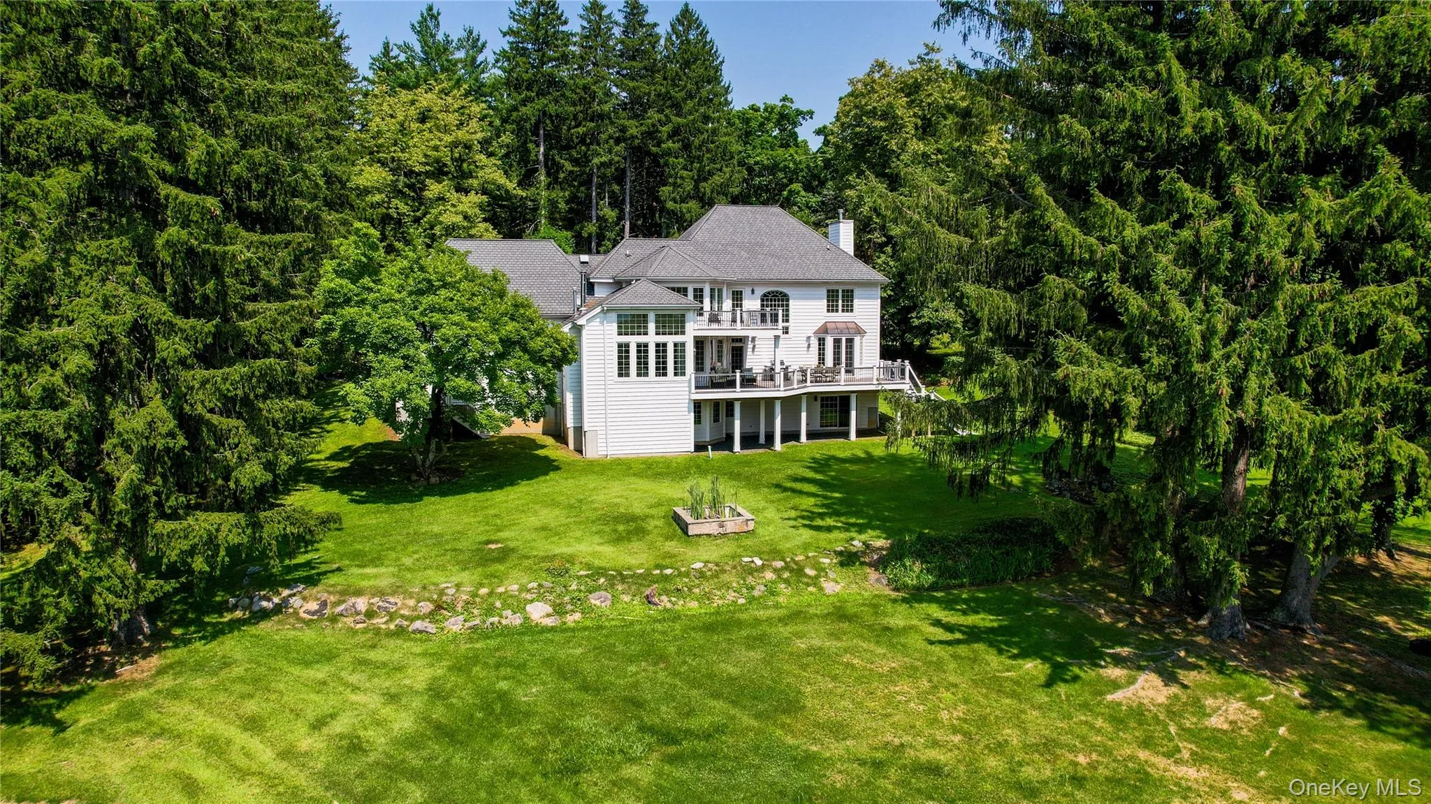 A stunning rear view of the home showcases its exceptional architecture and seamless connection to the beautifully landscaped grounds. A stunning rear view of the home showcases its exceptional architecture and seamless connection to the beautifully landscaped grounds.