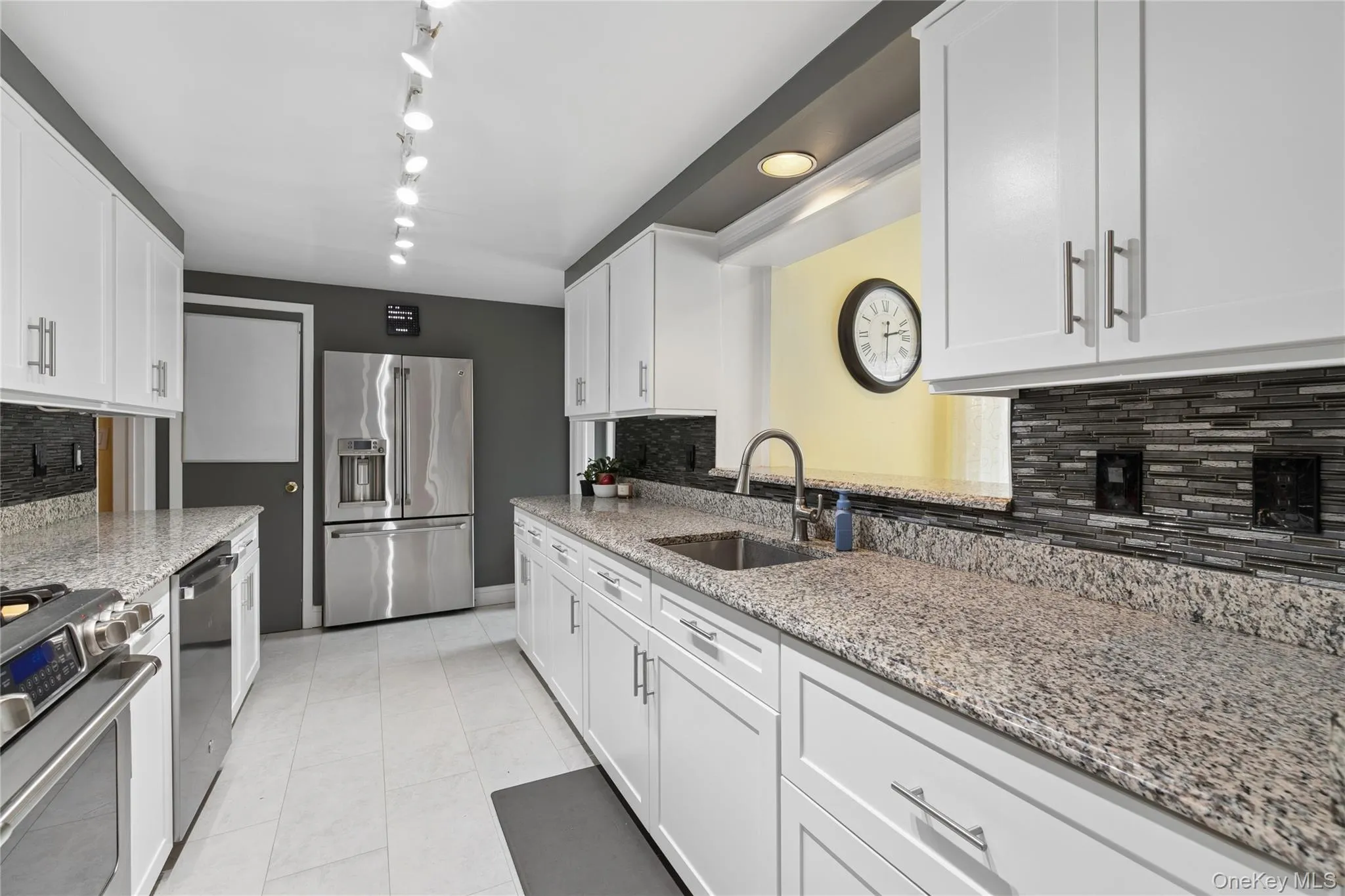 Galley kitchen with expansive white cabinetry, granite counters and updated appliances Galley kitchen with expansive white cabinetry, granite counters and updated appliances