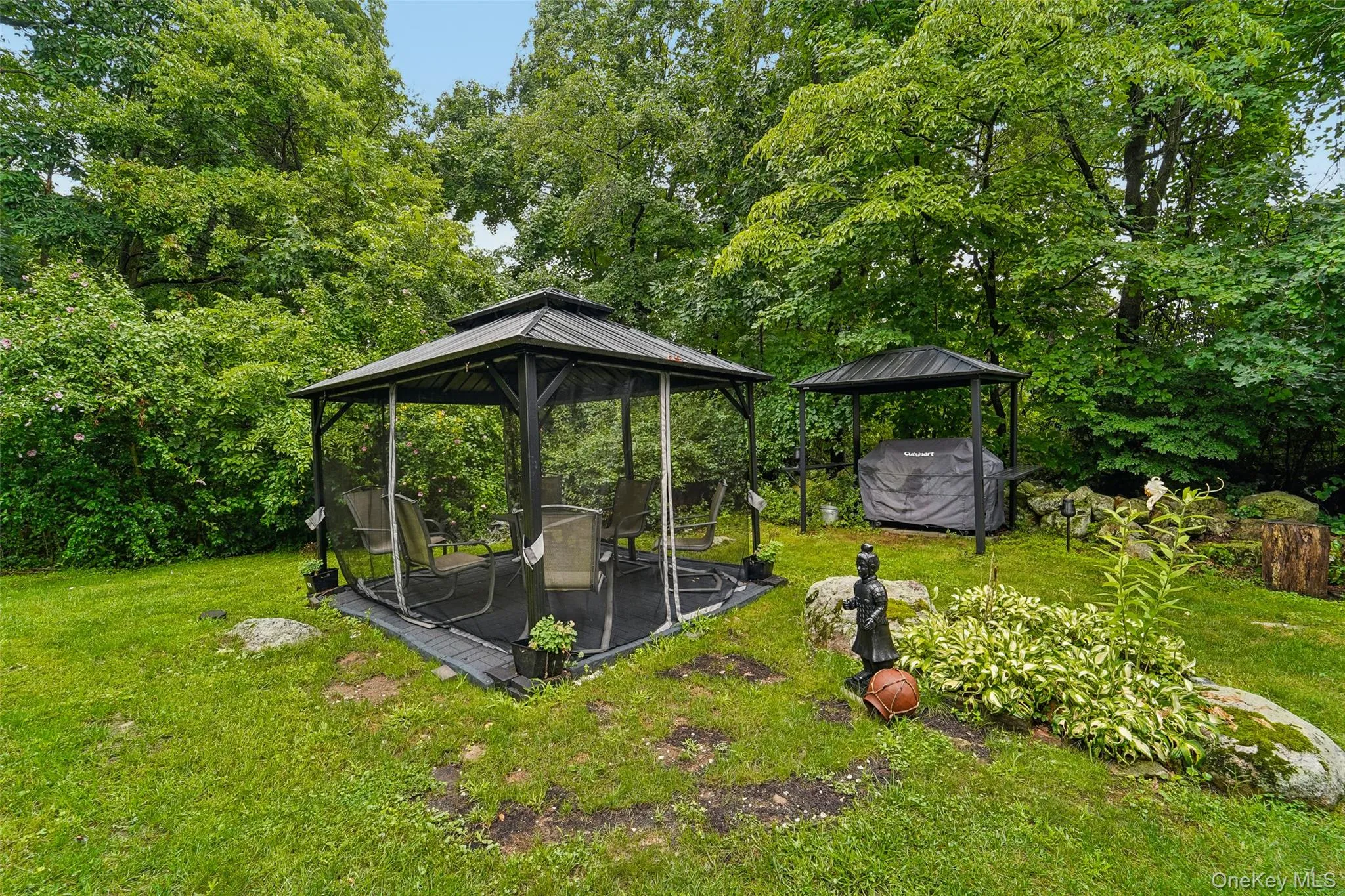 Backyard showing landscaping, covered grill, and screened hardtop gazebo. Backyard showing landscaping, covered grill, and screened hardtop gazebo.