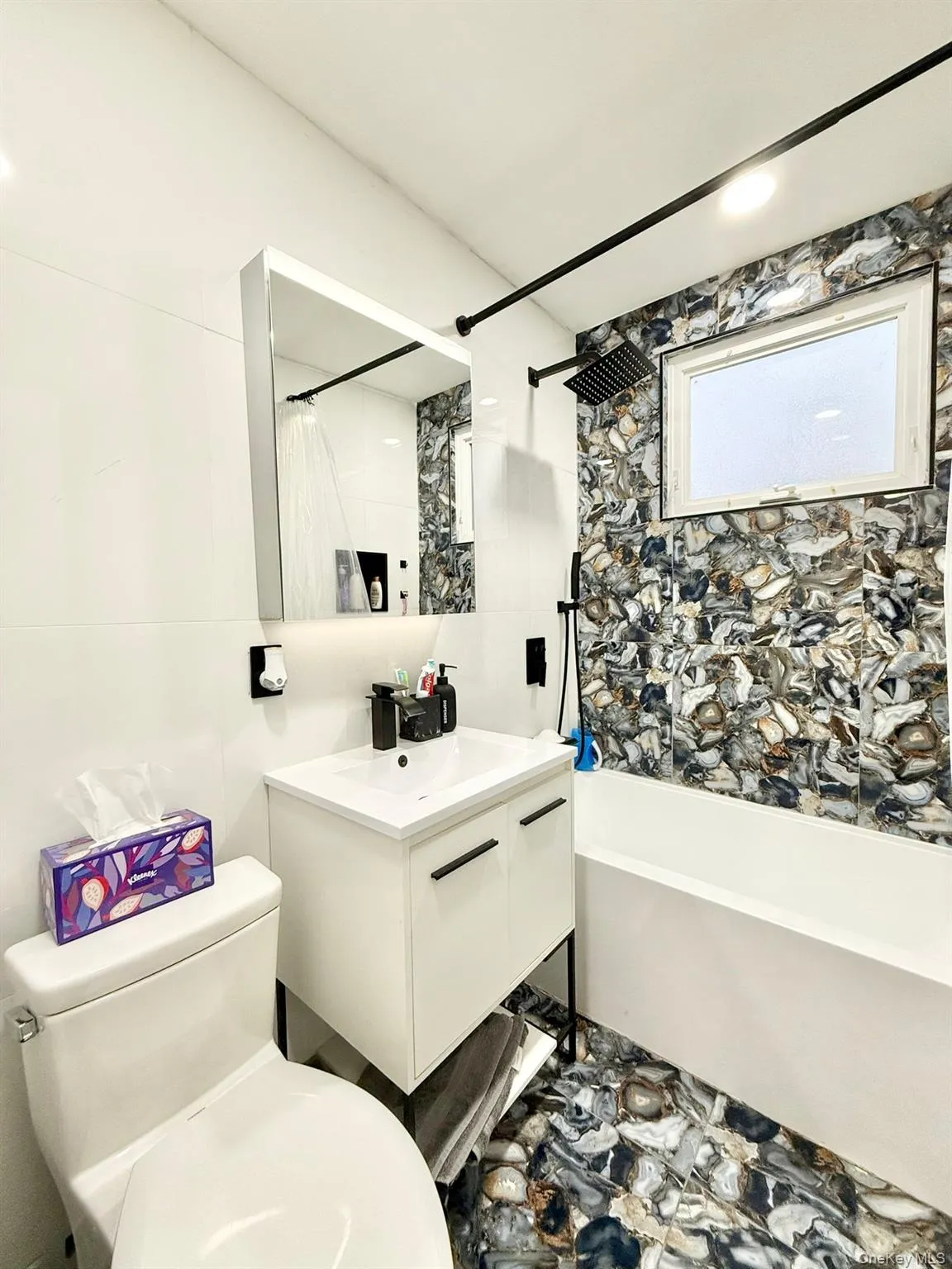 Contemporary bathroom featuring a unique stone-look tile accent wall and flooring Contemporary bathroom featuring a unique stone-look tile accent wall and flooring