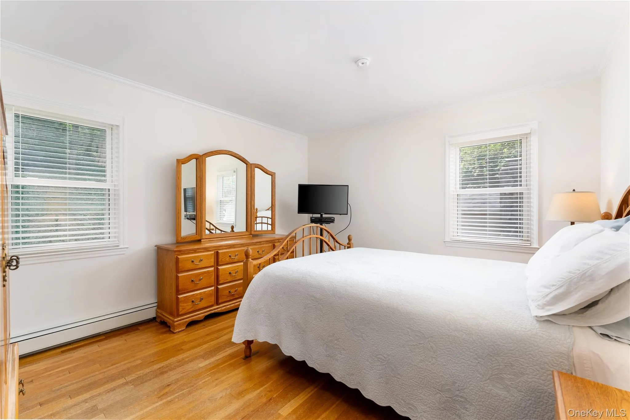 Hardwood flooring, painted white walls, white window blinds, and white trim Hardwood flooring, painted white walls, white window blinds, and white trim