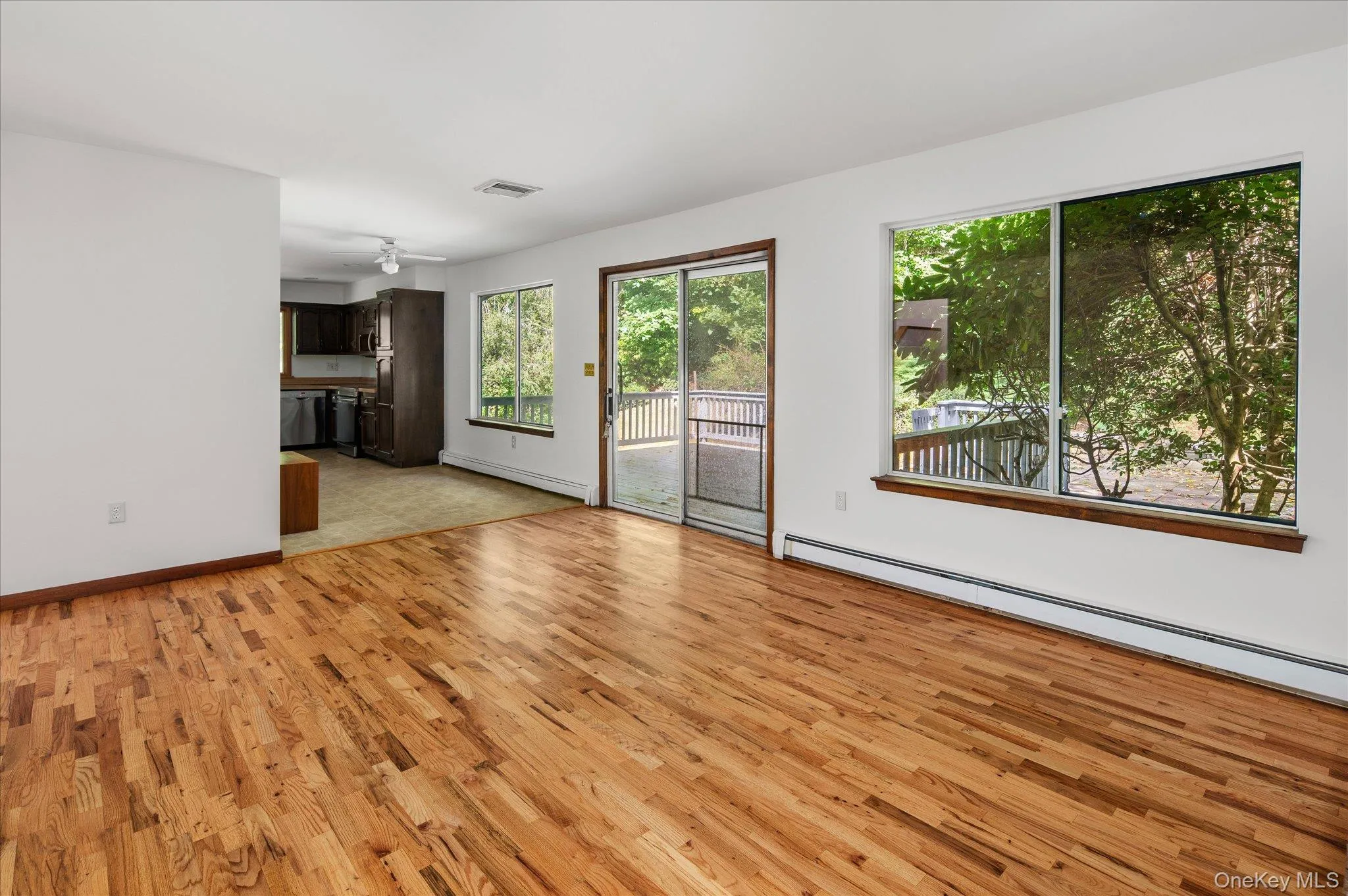 Opposite view of family room with sliders off deck and adjacent to the kitchen Opposite view of family room with sliders off deck and adjacent to the kitchen