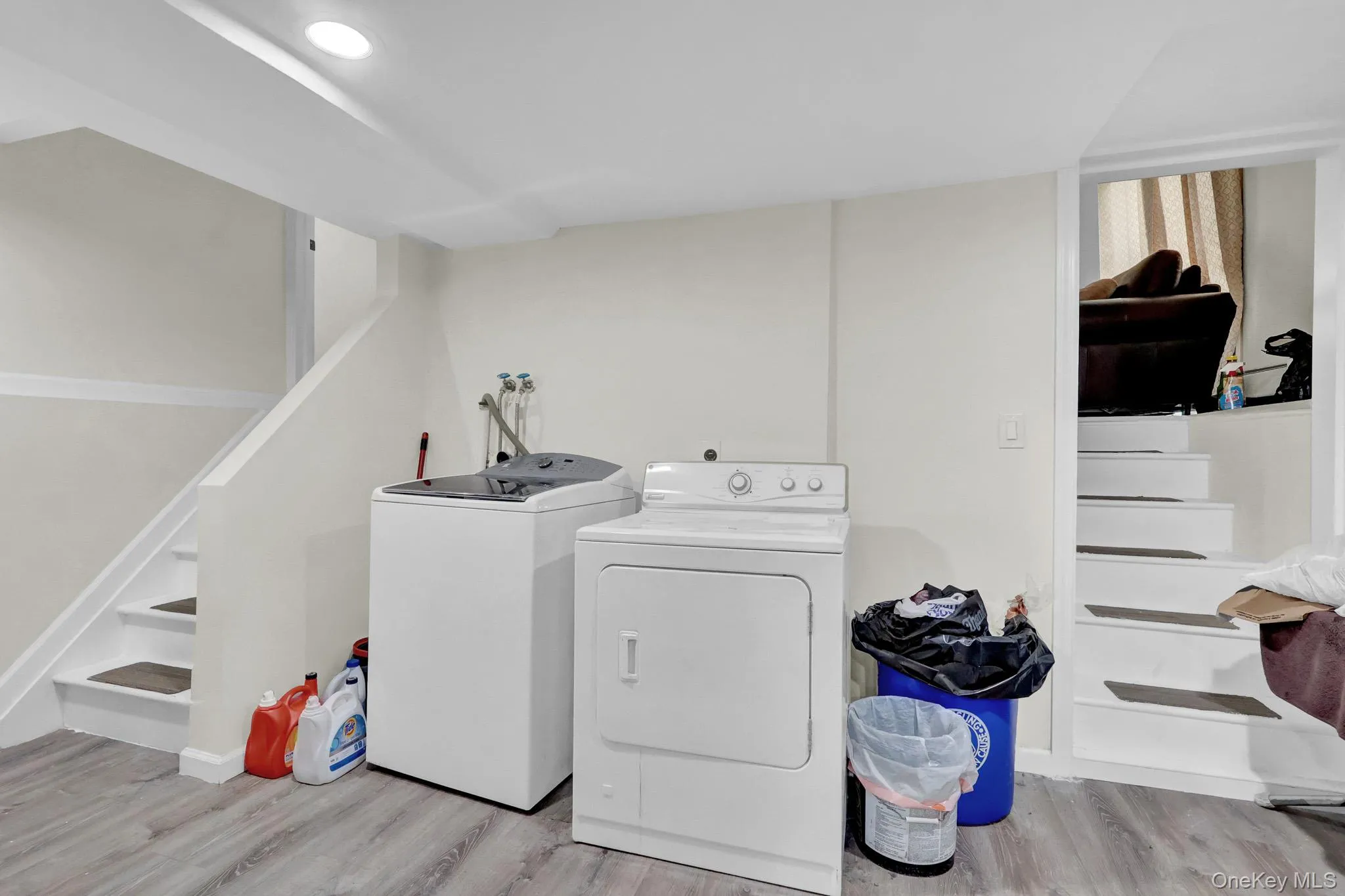 Dedicated laundry area featuring wood-finish flooring and recessed lighting Dedicated laundry area featuring wood-finish flooring and recessed lighting