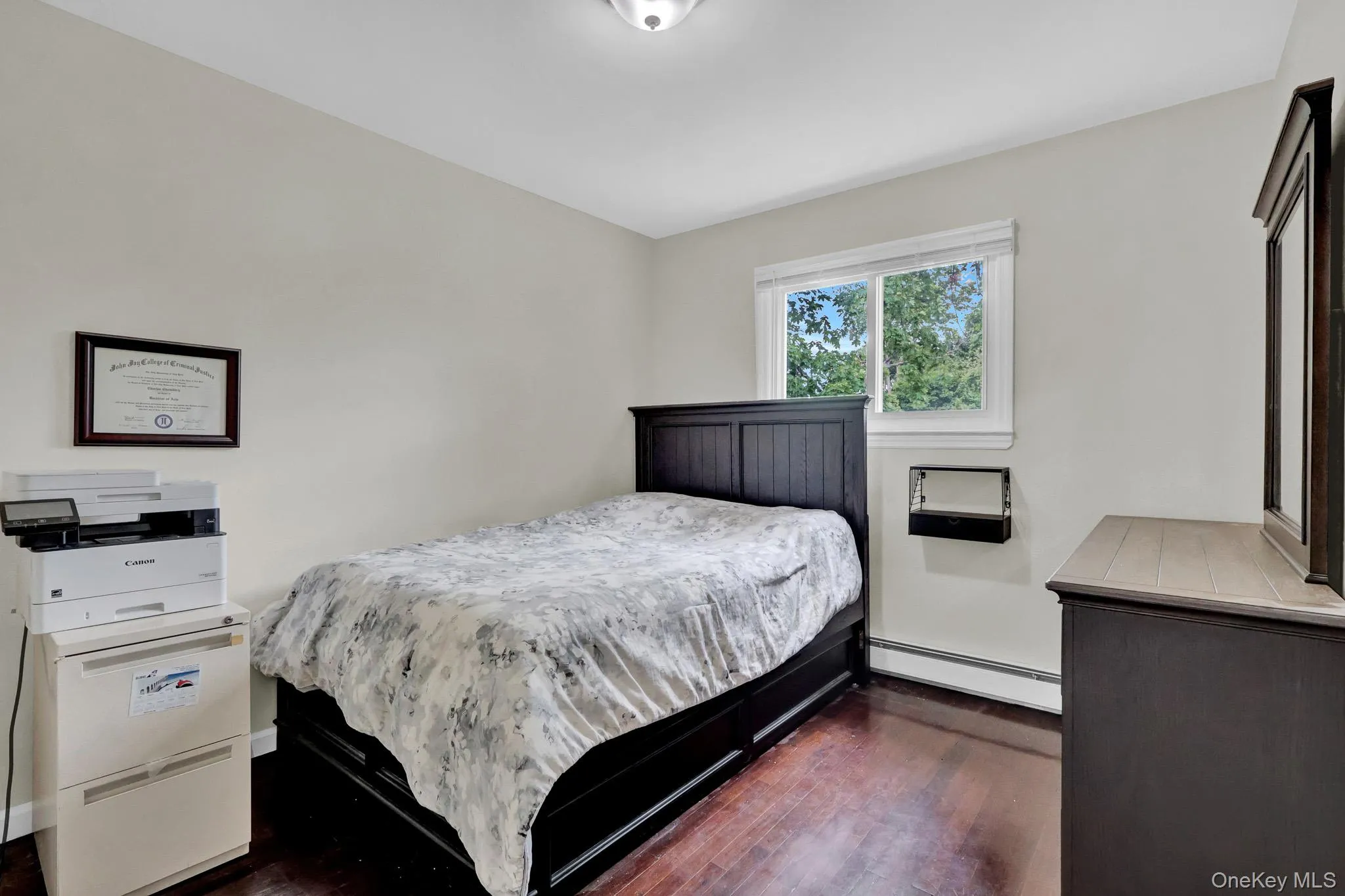 Room featuring wood-finish flooring, a double-hung window, light-toned walls, and a ceiling light fixture Room featuring wood-finish flooring, a double-hung window, light-toned walls, and a ceiling light fixture