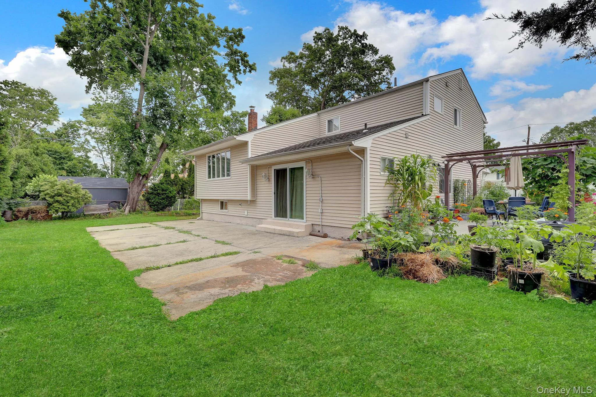 Expansive rear exterior featuring beige horizontal siding and a multi-level roofline Expansive rear exterior featuring beige horizontal siding and a multi-level roofline