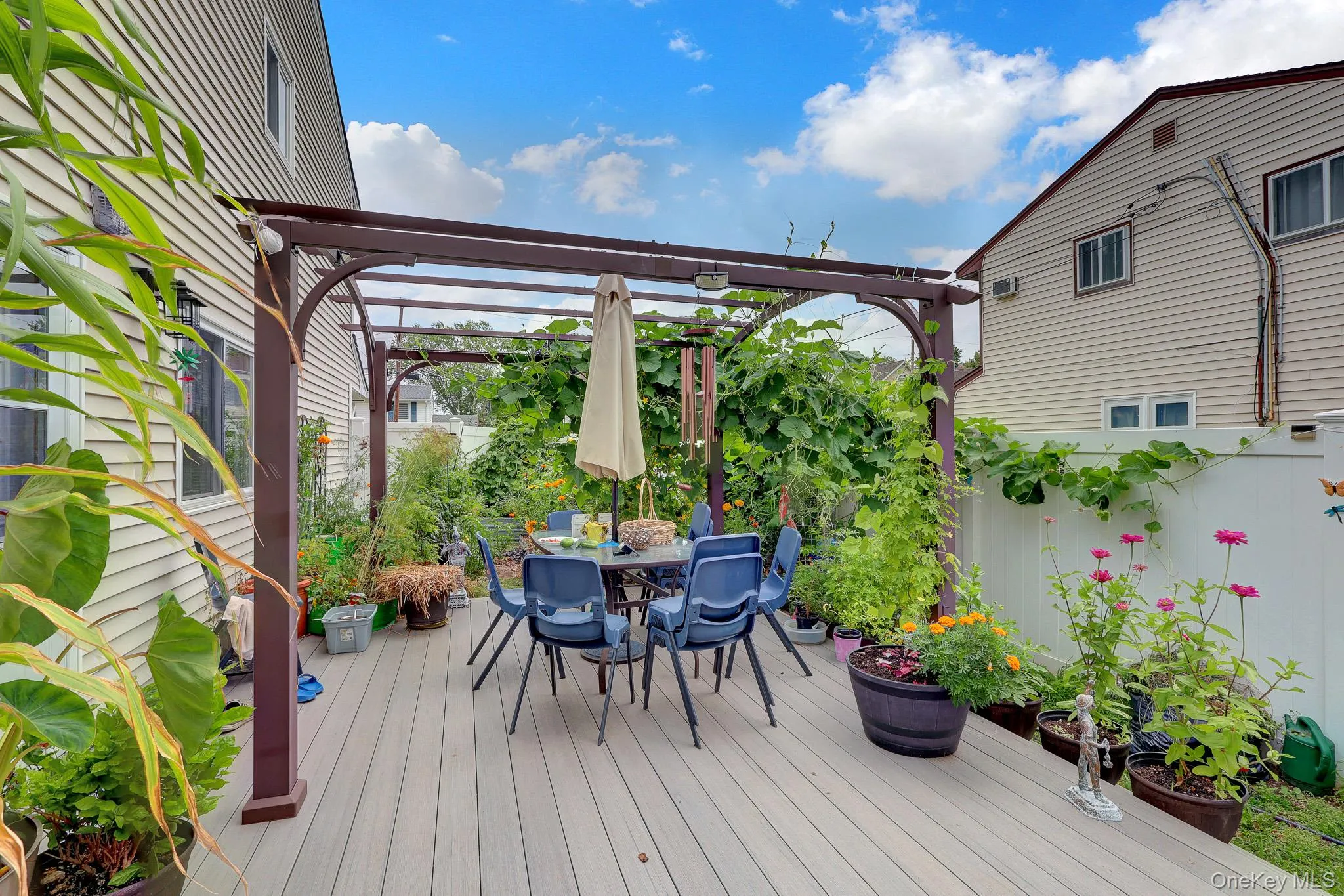Outdoor deck with a brown pergola structure and lush green foliage Outdoor deck with a brown pergola structure and lush green foliage
