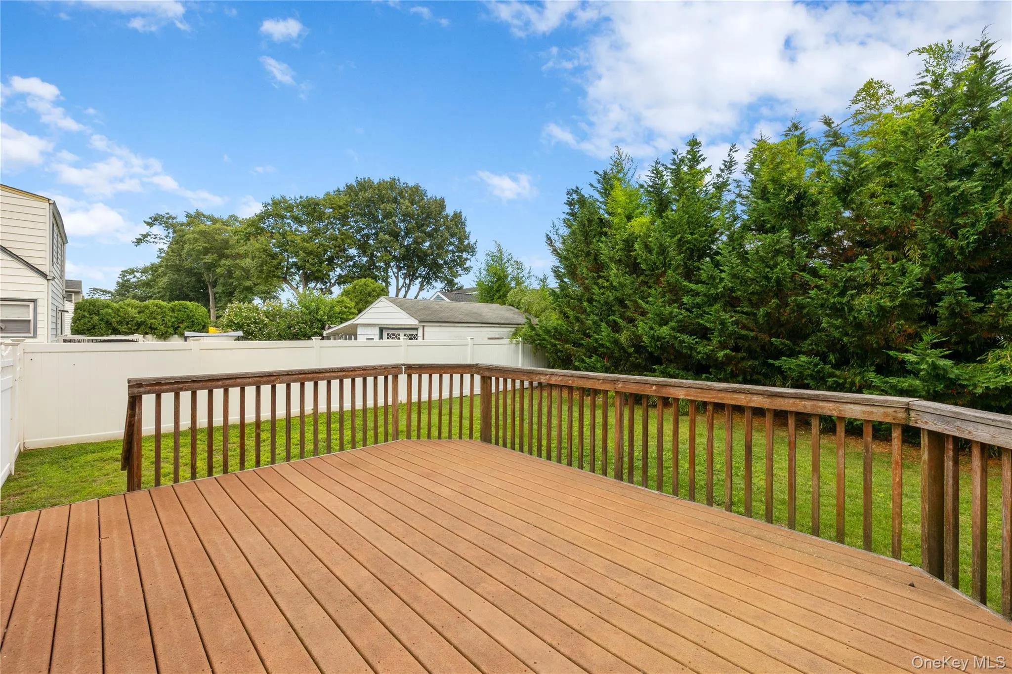 Spacious wooden deck featuring natural wood railing Spacious wooden deck featuring natural wood railing
