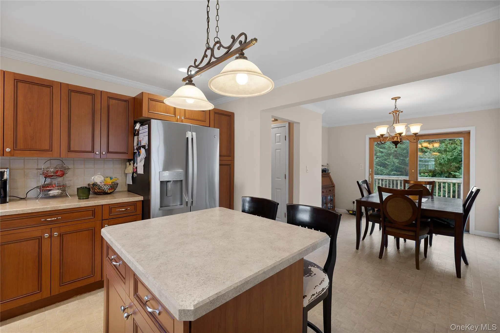 Kitchen featuring wood cabinetry, stone-finish countertops, stainless steel refrigerator, and tile flooring Kitchen featuring wood cabinetry, stone-finish countertops, stainless steel refrigerator, and tile flooring
