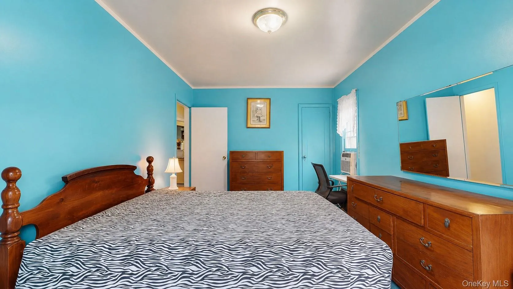 Interior room featuring vibrant blue walls and a white ceiling with a flush-mount light fixture Interior room featuring vibrant blue walls and a white ceiling with a flush-mount light fixture