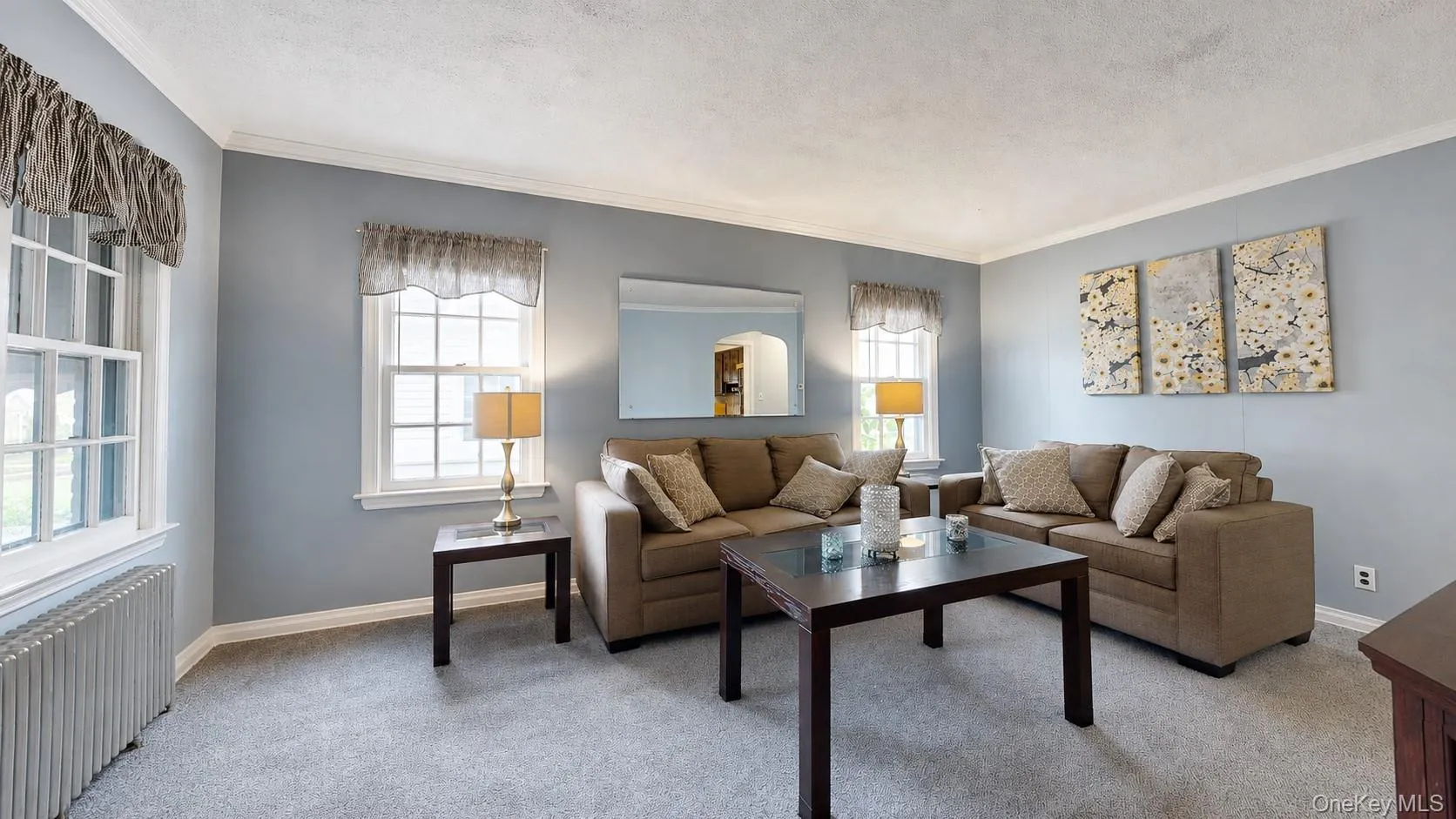 Living room with light-colored walls and grey carpeting Living room with light-colored walls and grey carpeting