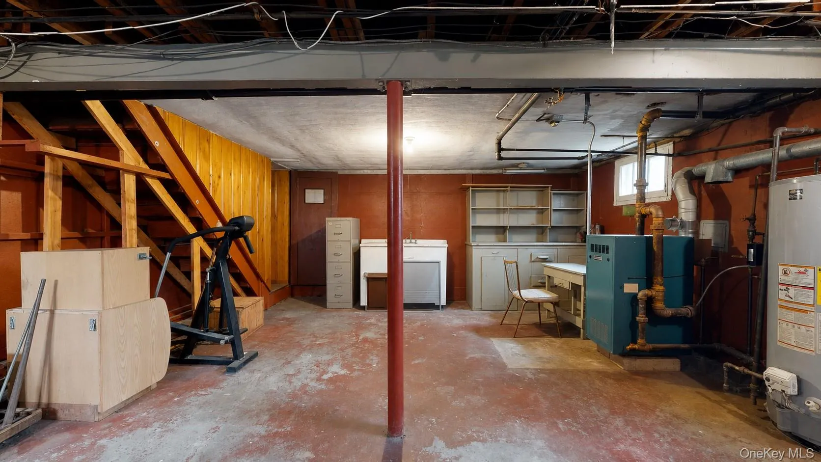 Spacious basement featuring painted concrete flooring, exposed ceiling beams, and a utility sink Spacious basement featuring painted concrete flooring, exposed ceiling beams, and a utility sink