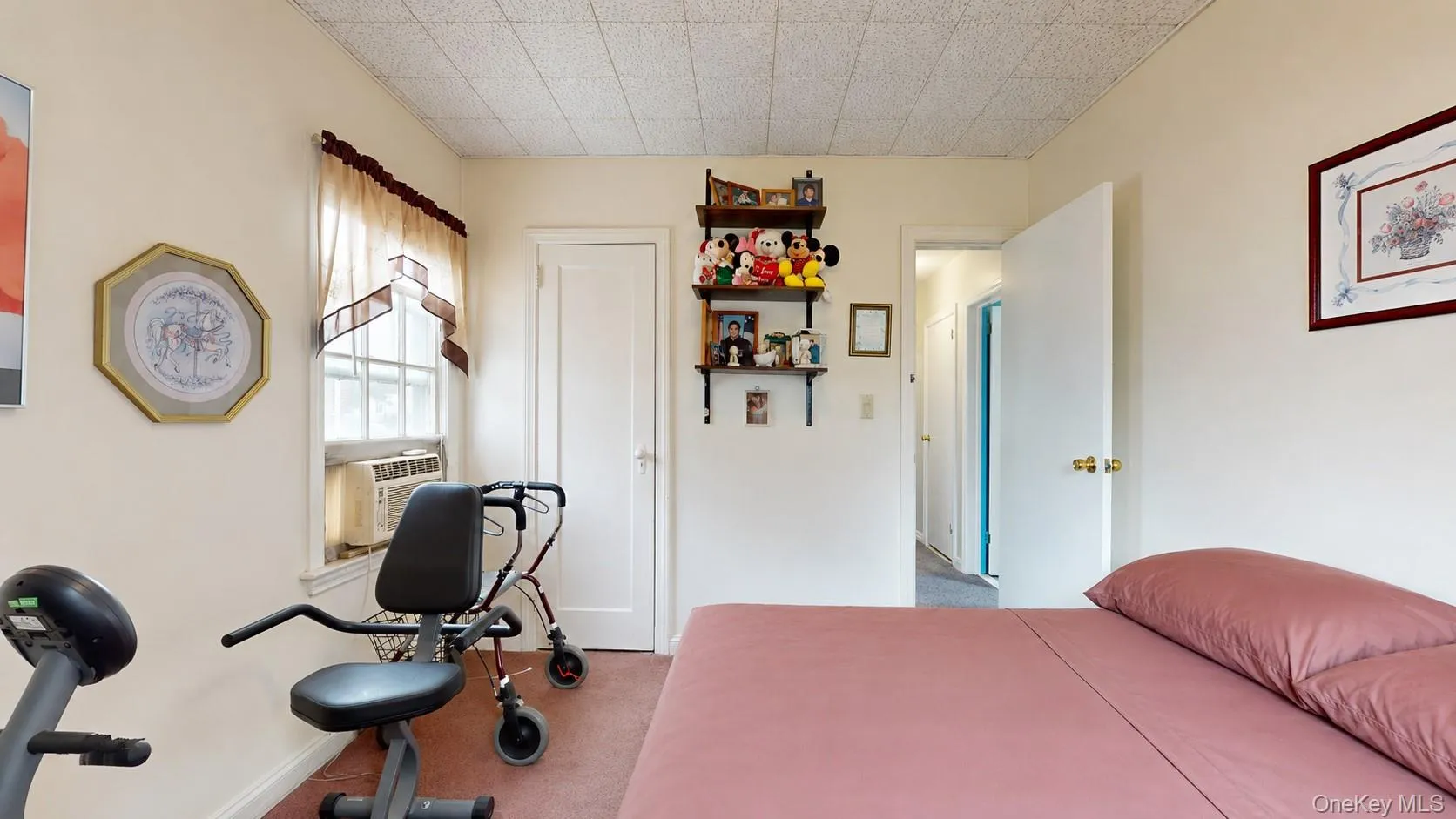 Interior room featuring a drop ceiling, a single window with curtain, and light-toned walls Interior room featuring a drop ceiling, a single window with curtain, and light-toned walls