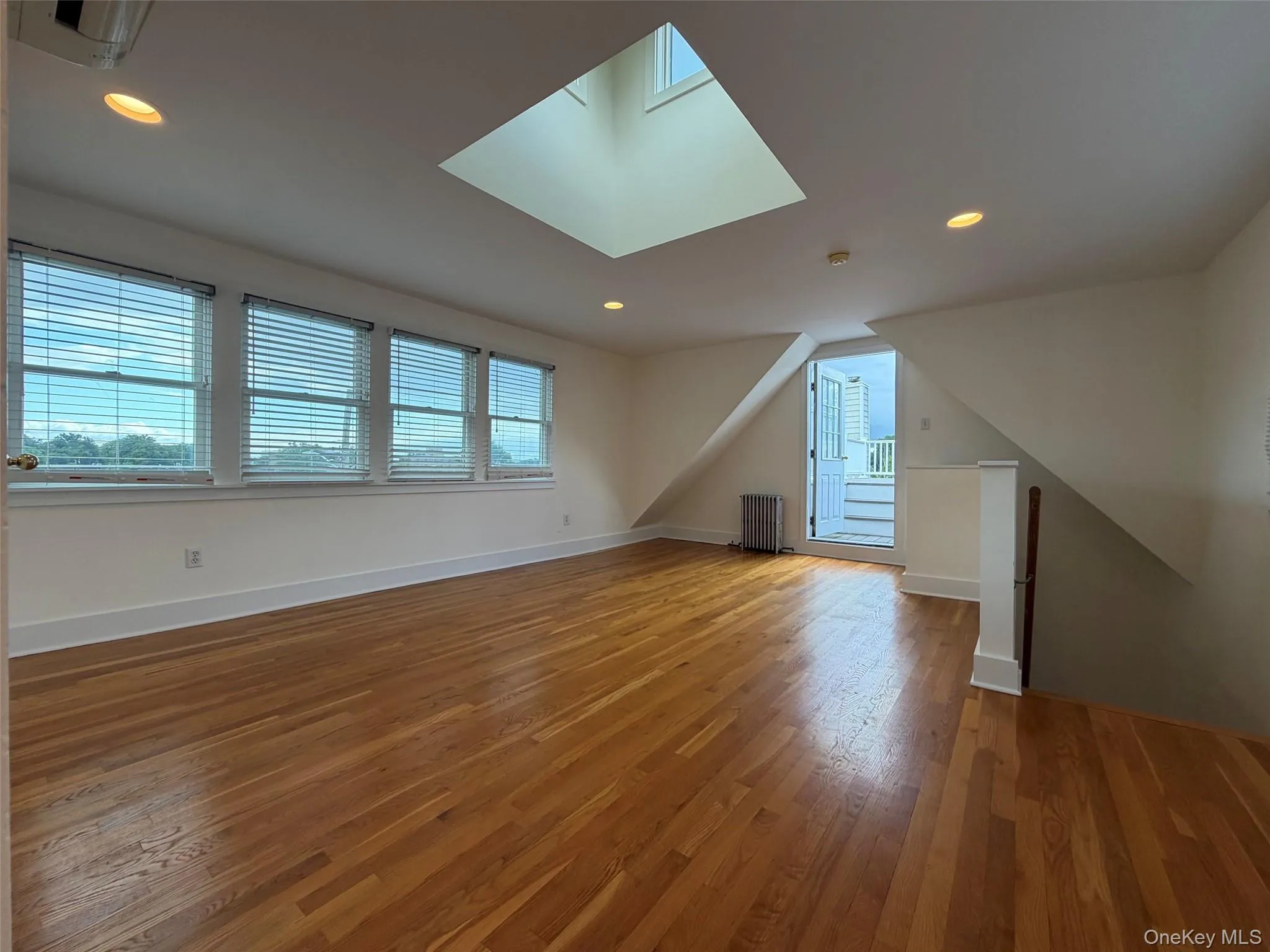Primary bedroom with skylights and private deck Primary bedroom with skylights and private deck
