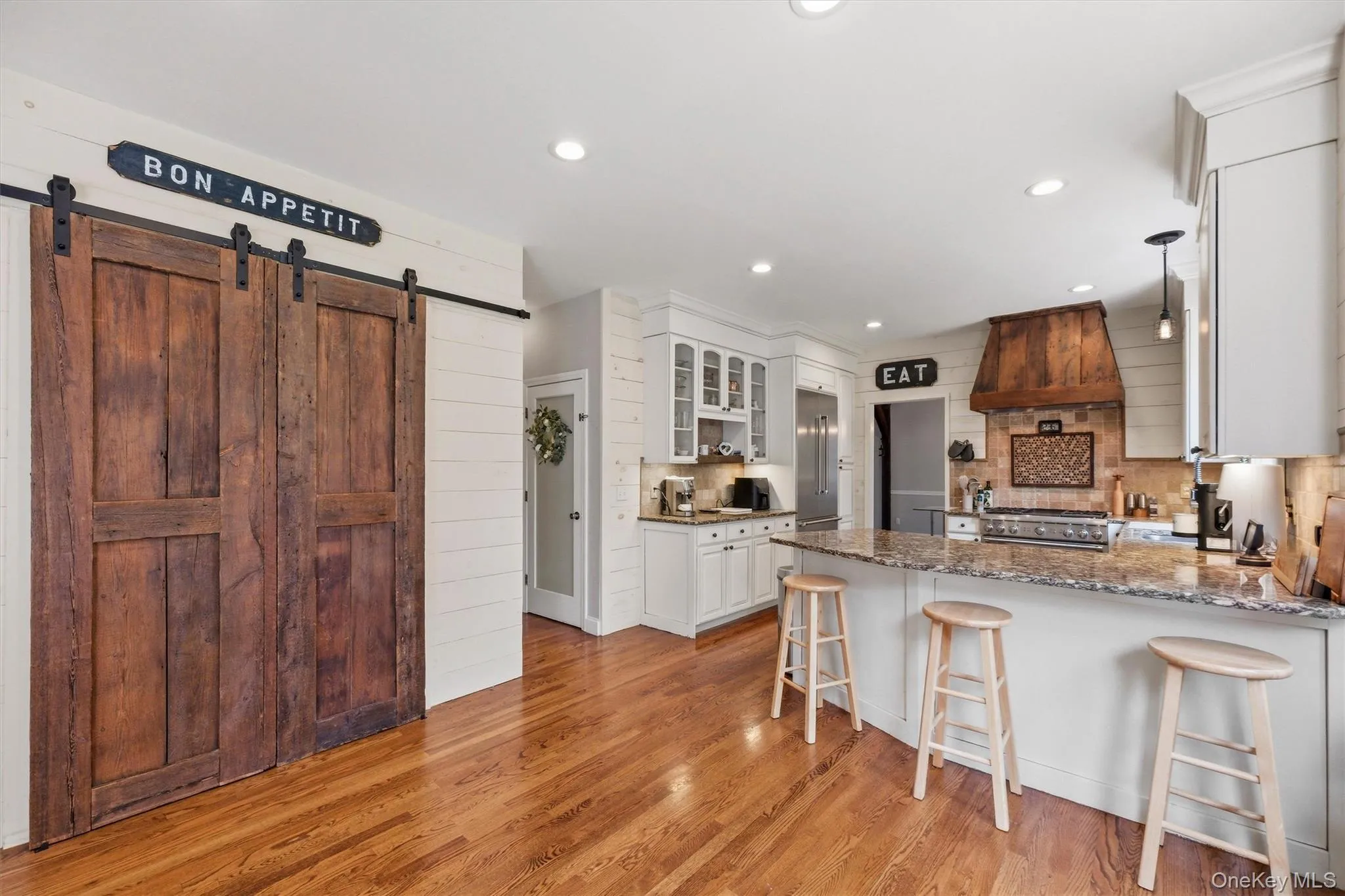 A custom walk-in pantry, beautifully appointed with reclaimed wood doors, provides additional storage while adding warmth and character to the space. A custom walk-in pantry, beautifully appointed with reclaimed wood doors, provides additional storage while adding warmth and character to the space.