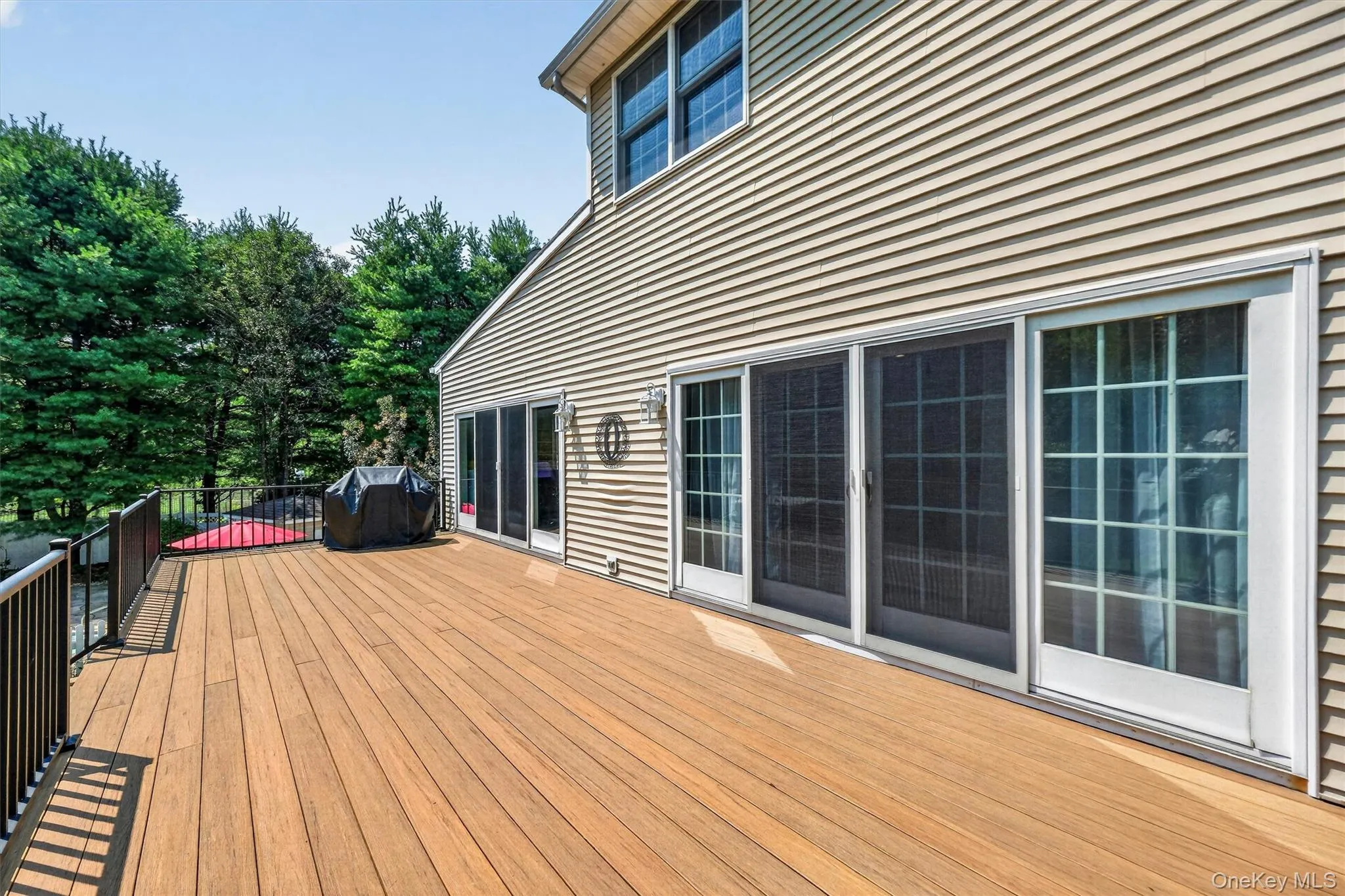 The top-level of the deck can be accessed via sliders from both the family and sun rooms. The top-level of the deck can be accessed via sliders from both the family and sun rooms.
