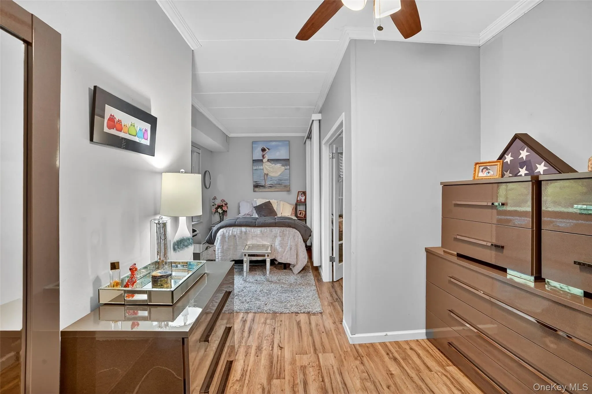 Bedroom with ornamental molding, light wood-type flooring, and ceiling fan Bedroom with ornamental molding, light wood-type flooring, and ceiling fan