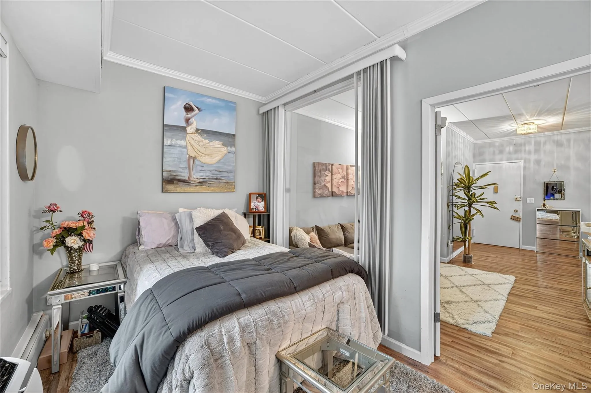 Bedroom with light wood-style floors and ornamental molding Bedroom with light wood-style floors and ornamental molding
