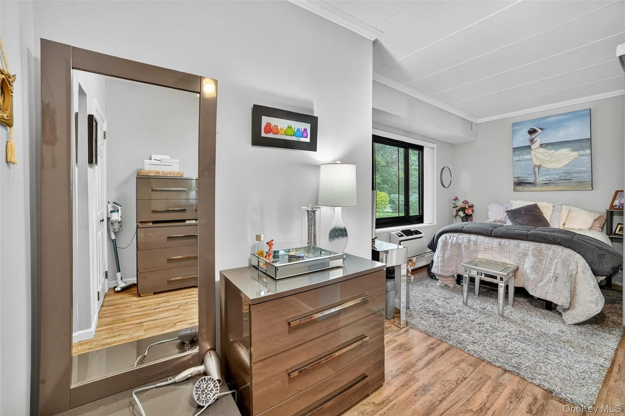 Bedroom with ornamental molding and light wood-style floors Bedroom with ornamental molding and light wood-style floors