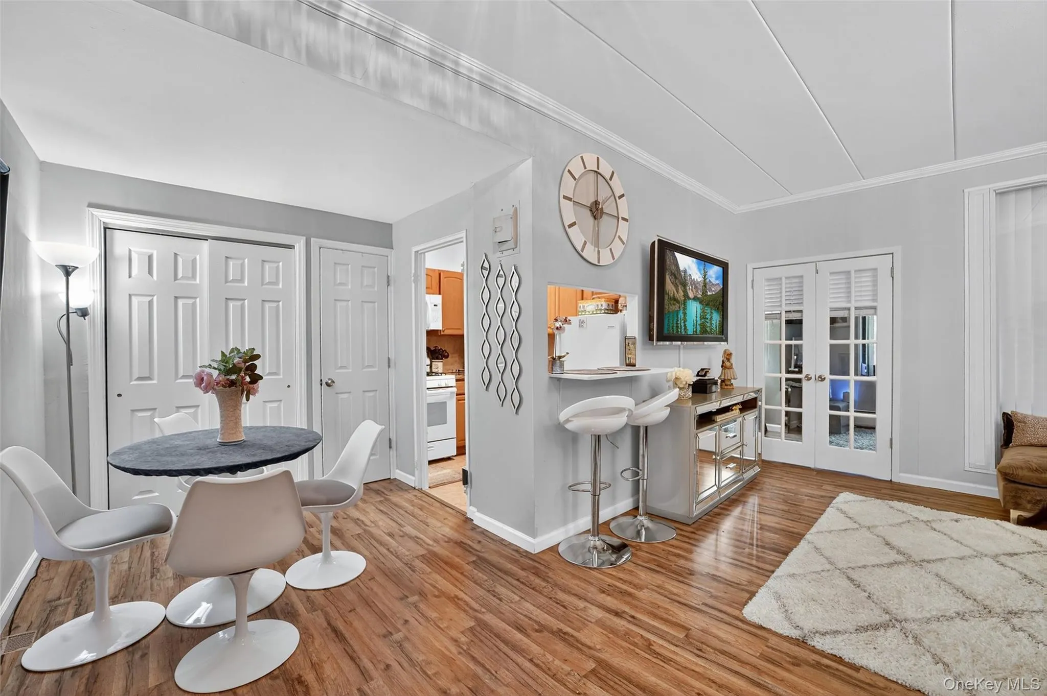 Dining room featuring light wood finished floors, french doors, and ornamental molding Dining room featuring light wood finished floors, french doors, and ornamental molding
