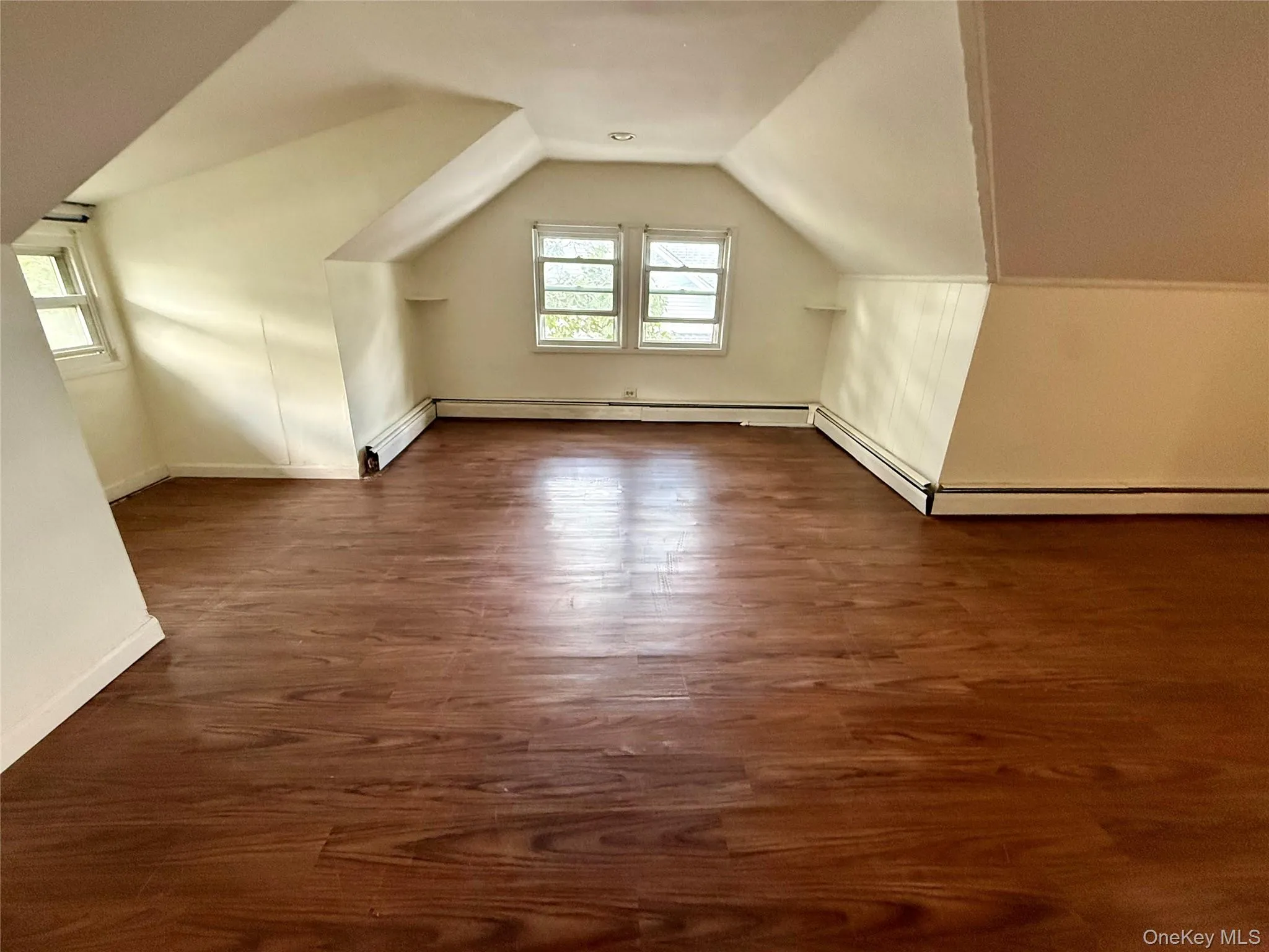 Second Floor, Third Bedroom, featuring wood-finish flooring, multiple windows, and baseboard heating Second Floor, Third Bedroom, featuring wood-finish flooring, multiple windows, and baseboard heating