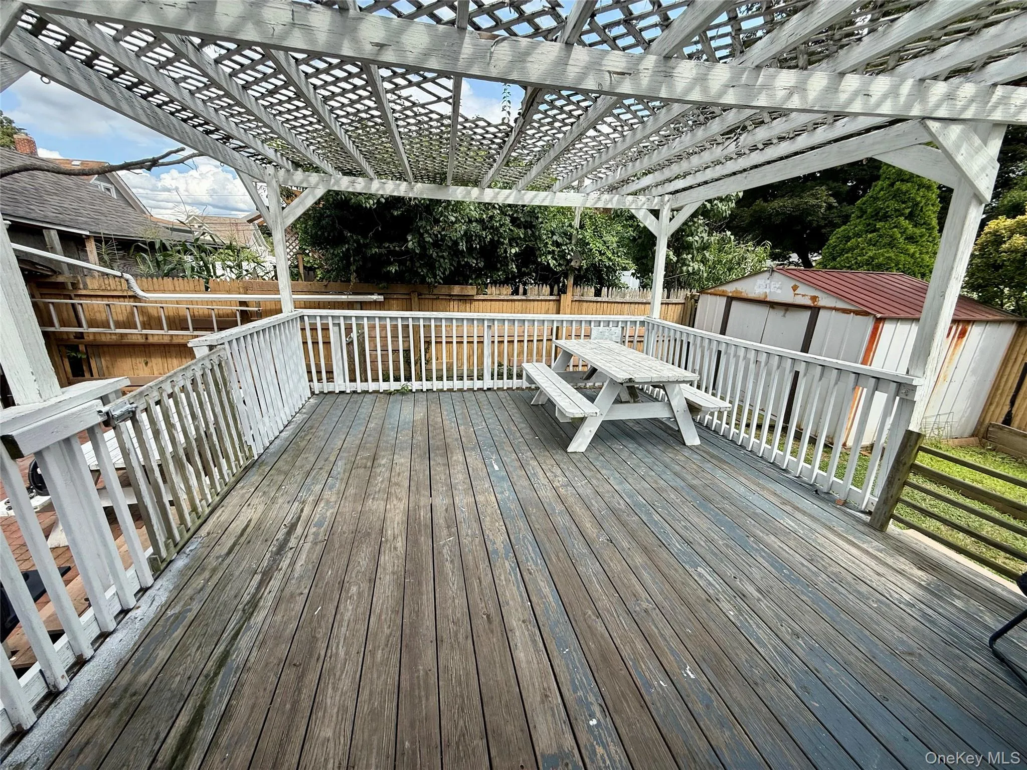 Outdoor deck featuring wood flooring and white baluster railing Outdoor deck featuring wood flooring and white baluster railing