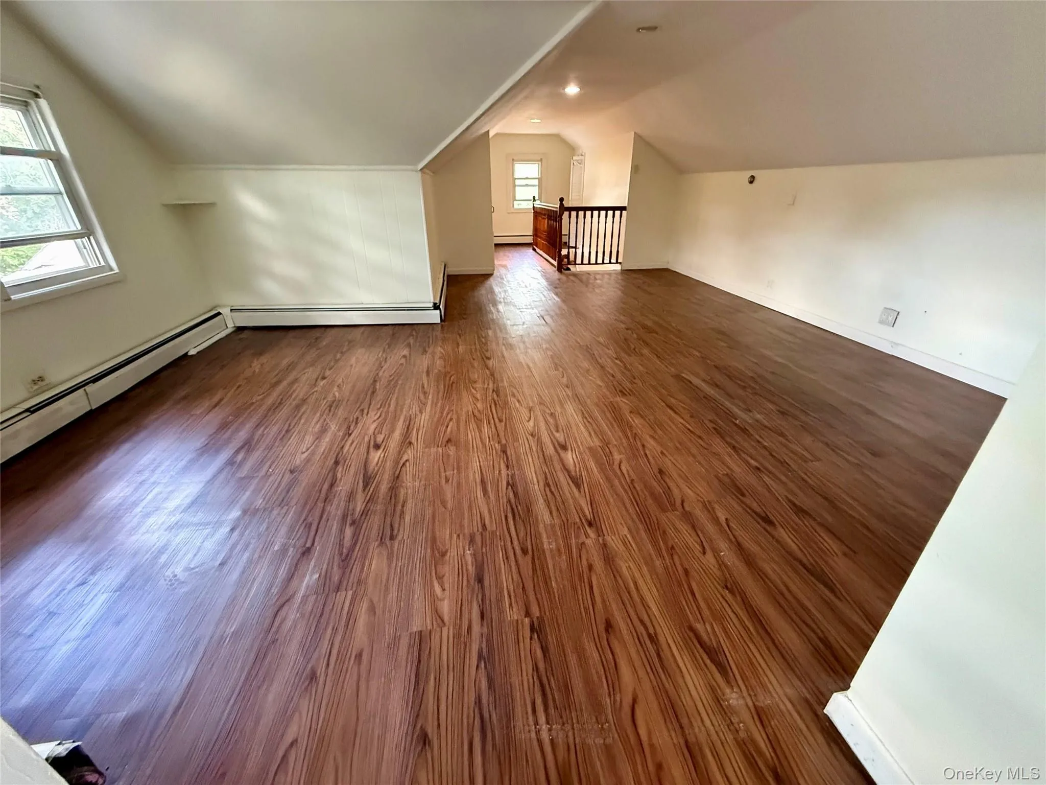 Second Floor, Third Bedroom, featuring wood-finish flooring, multiple windows, and baseboard heating Second Floor, Third Bedroom, featuring wood-finish flooring, multiple windows, and baseboard heating