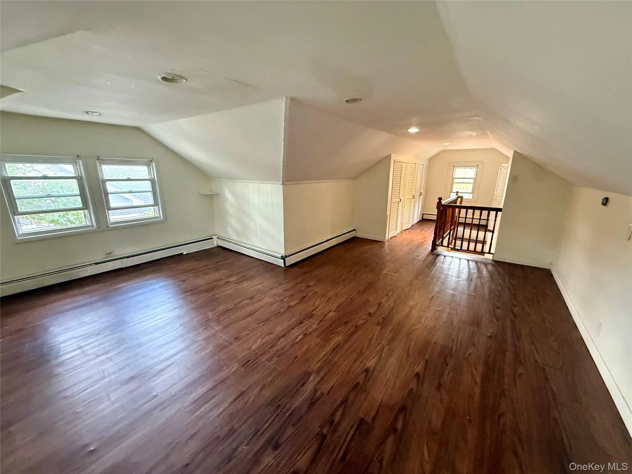 Second Floor, Third Bedroom, featuring wood-finish flooring, multiple windows, and baseboard heating Second Floor, Third Bedroom, featuring wood-finish flooring, multiple windows, and baseboard heating