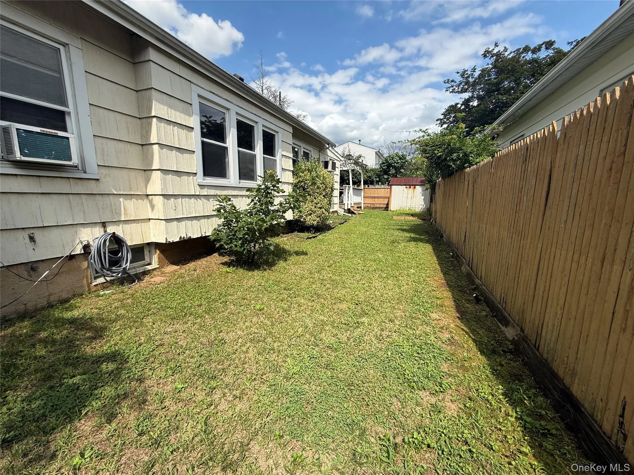 Expansive backyard featuring a manicured lawn, a full-height privacy fence, and mature landscaping Expansive backyard featuring a manicured lawn, a full-height privacy fence, and mature landscaping