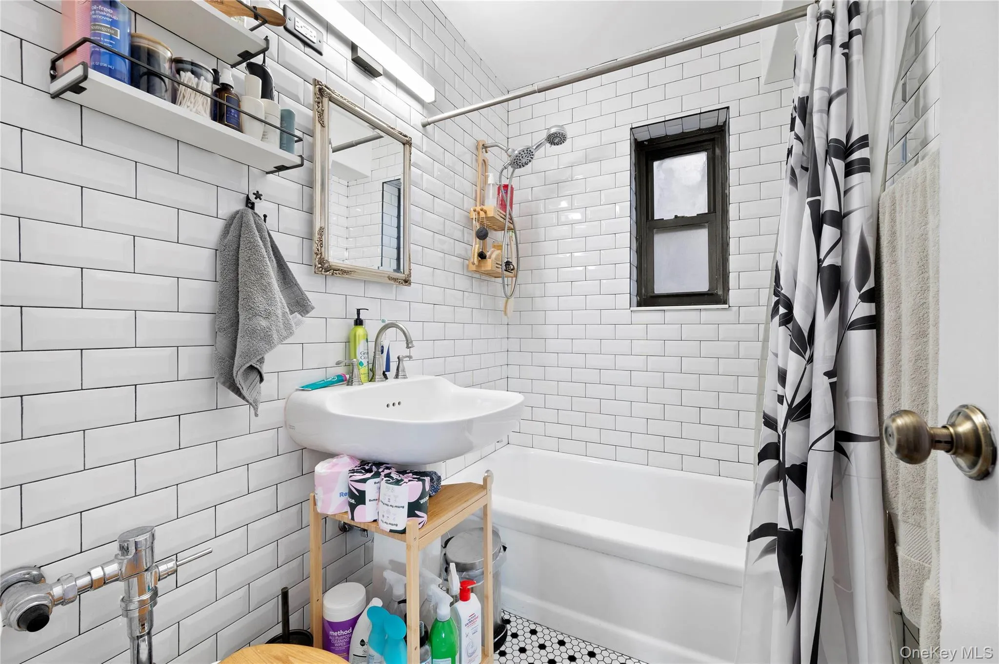 Bathroom featuring white subway tile walls, a wall-mounted sink, mosaic tile and a combination tub and shower Bathroom featuring white subway tile walls, a wall-mounted sink, mosaic tile and a combination tub and shower