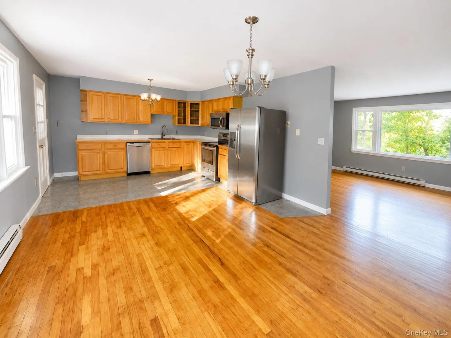 Open-concept living space with lustrous hardwood flooring throughout Open-concept living space with lustrous hardwood flooring throughout