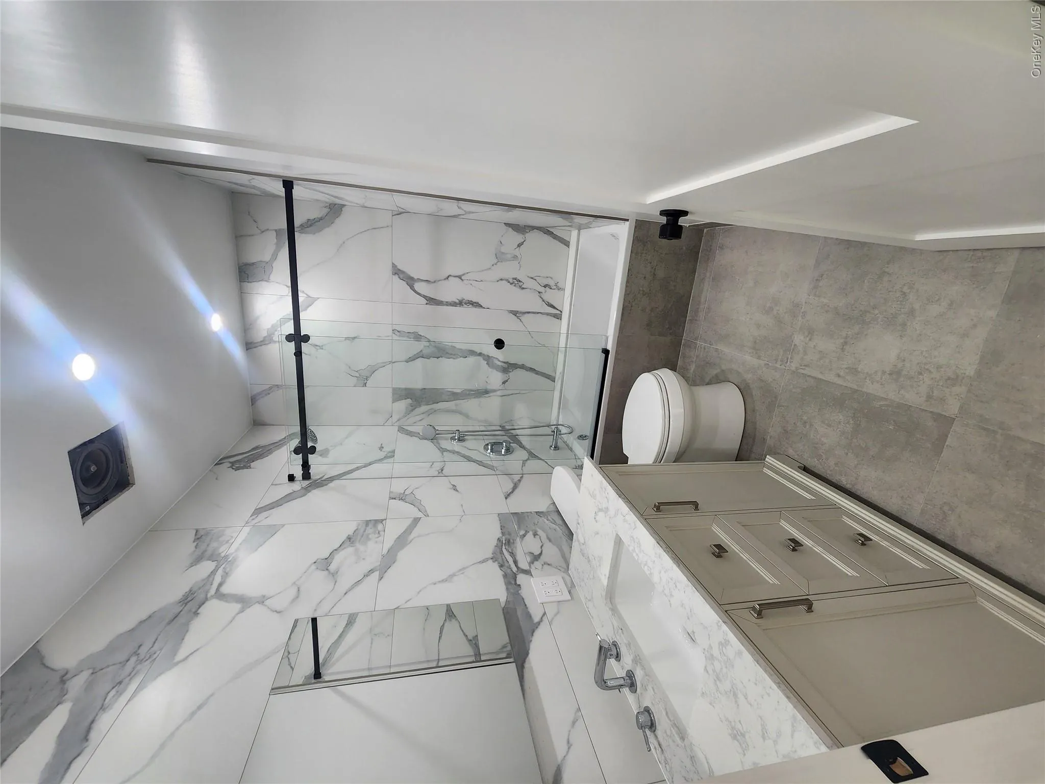 Contemporary bathroom featuring a light gray vanity with a stone-finish countertop, undermount sink, and chrome-finish fixtures Contemporary bathroom featuring a light gray vanity with a stone-finish countertop, undermount sink, and chrome-finish fixtures