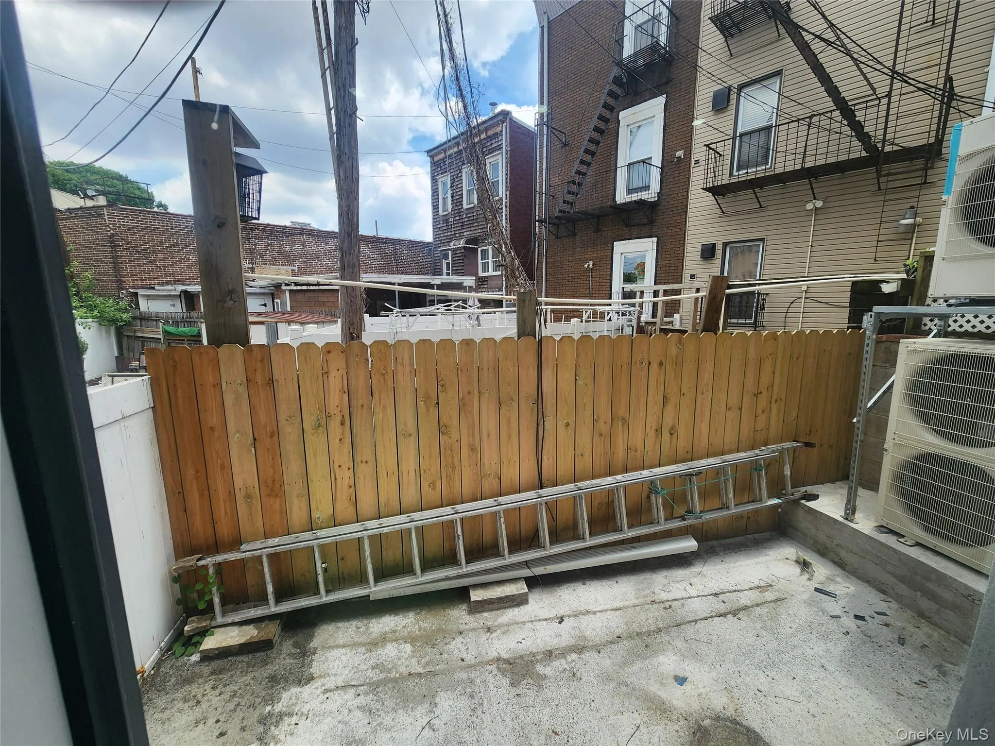 Paved outdoor area featuring a wooden privacy fence from your bedroom Paved outdoor area featuring a wooden privacy fence from your bedroom