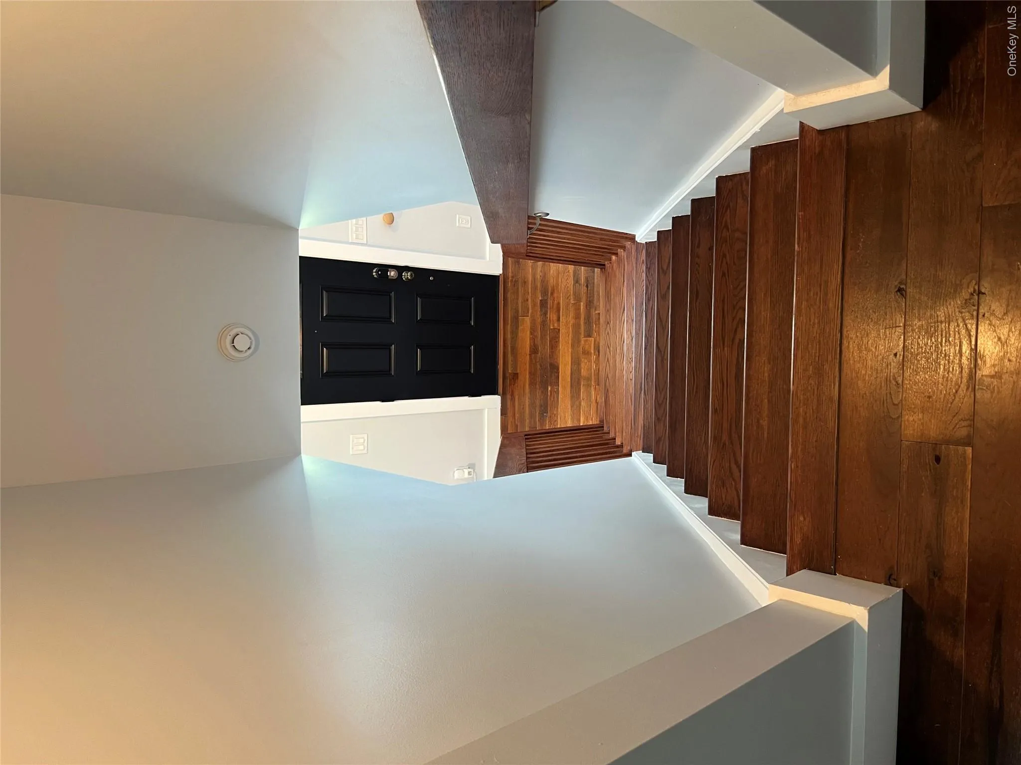 Hardwood staircase with natural wood balusters and a dark wood handrail Hardwood staircase with natural wood balusters and a dark wood handrail